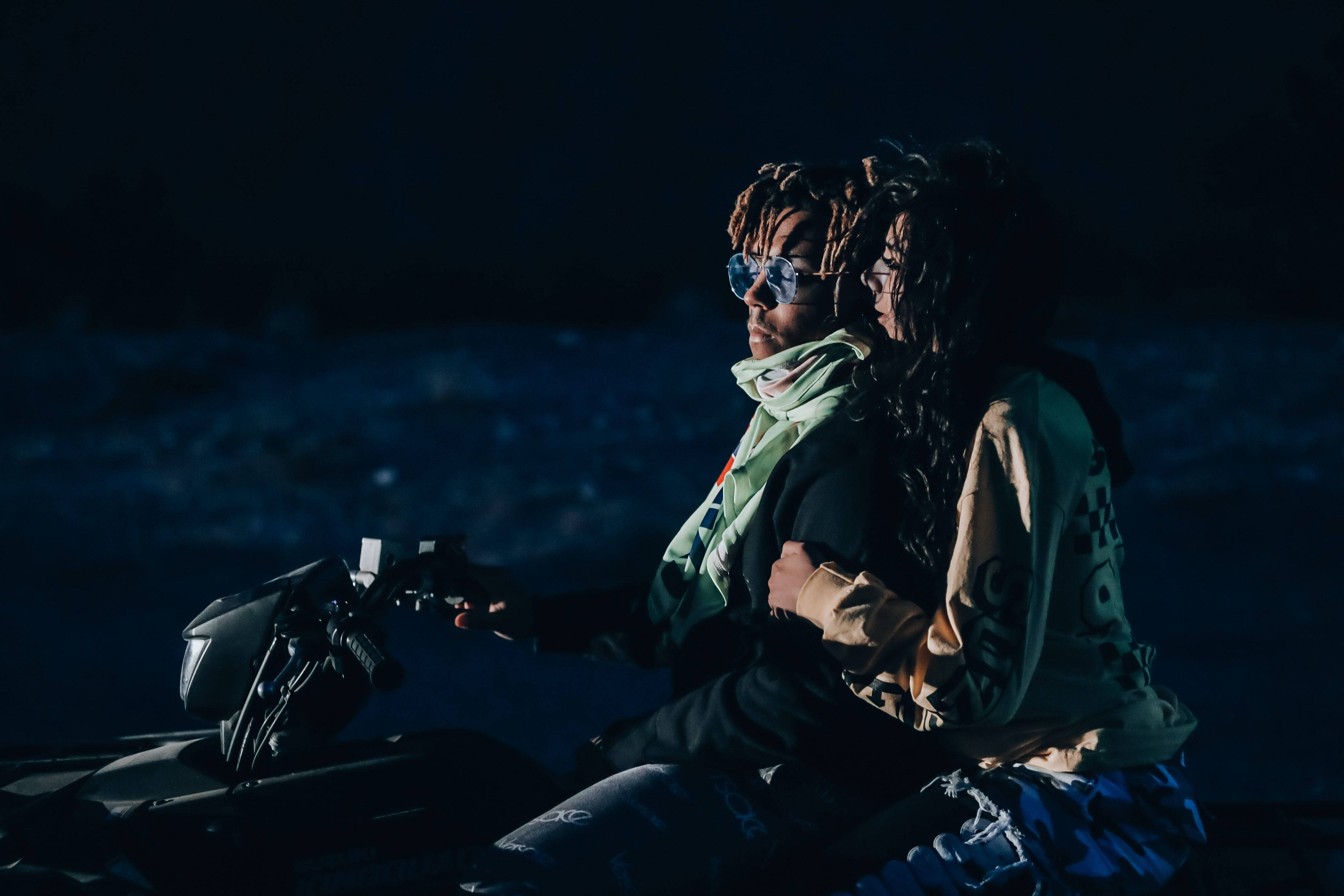 Juice Wrld 桌面女孩 壁紙 — 兩個梳著辮子頭的人夜晚坐在電單車上，背景黑暗，燈光呈冷藍色。