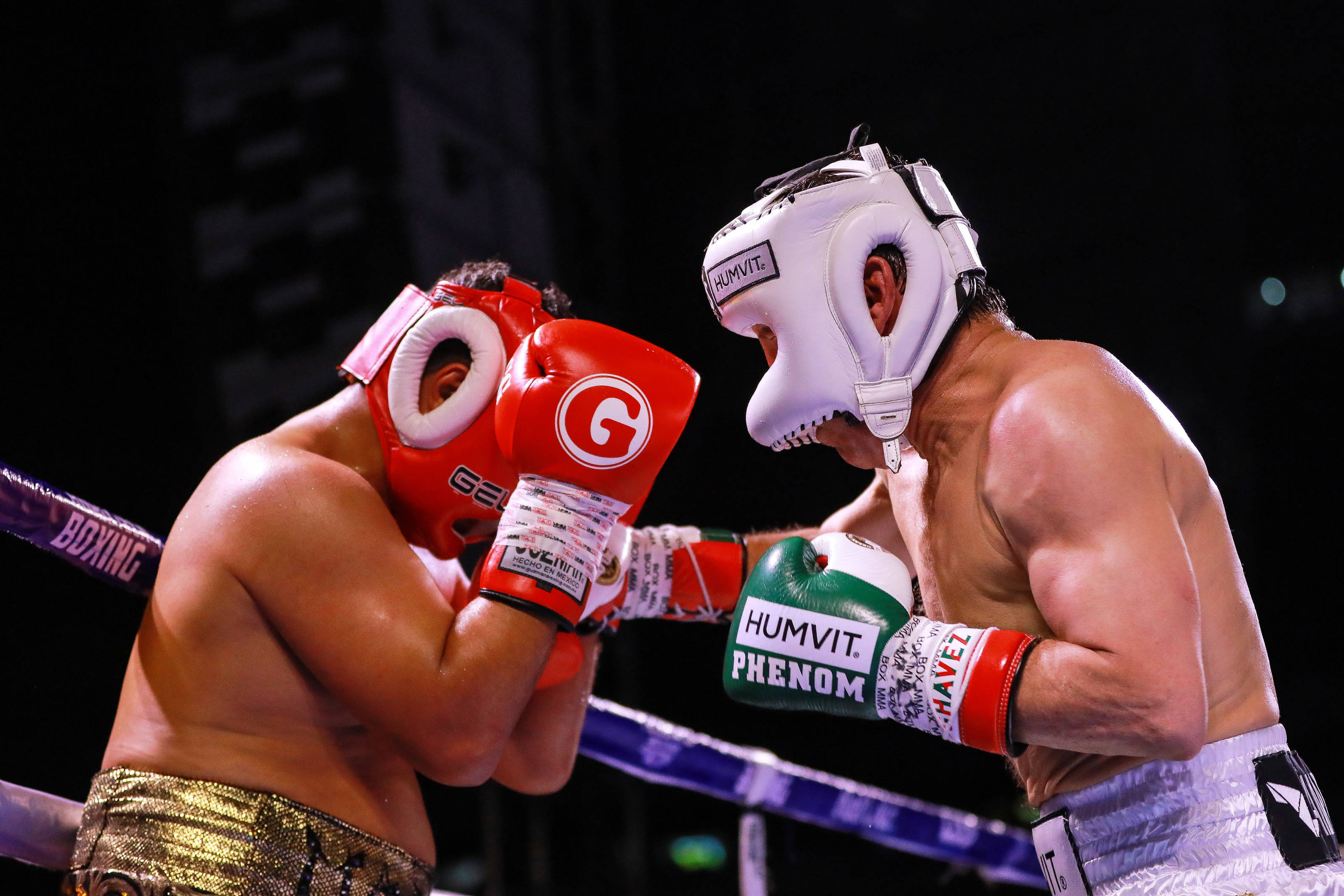 Julio César Chávez 對戰 Hector Camacho Jr. 壁紙 — 兩名拳擊手在明亮的場館燈光下，戴著紅白手套，在緊張的擂台上交鋒。