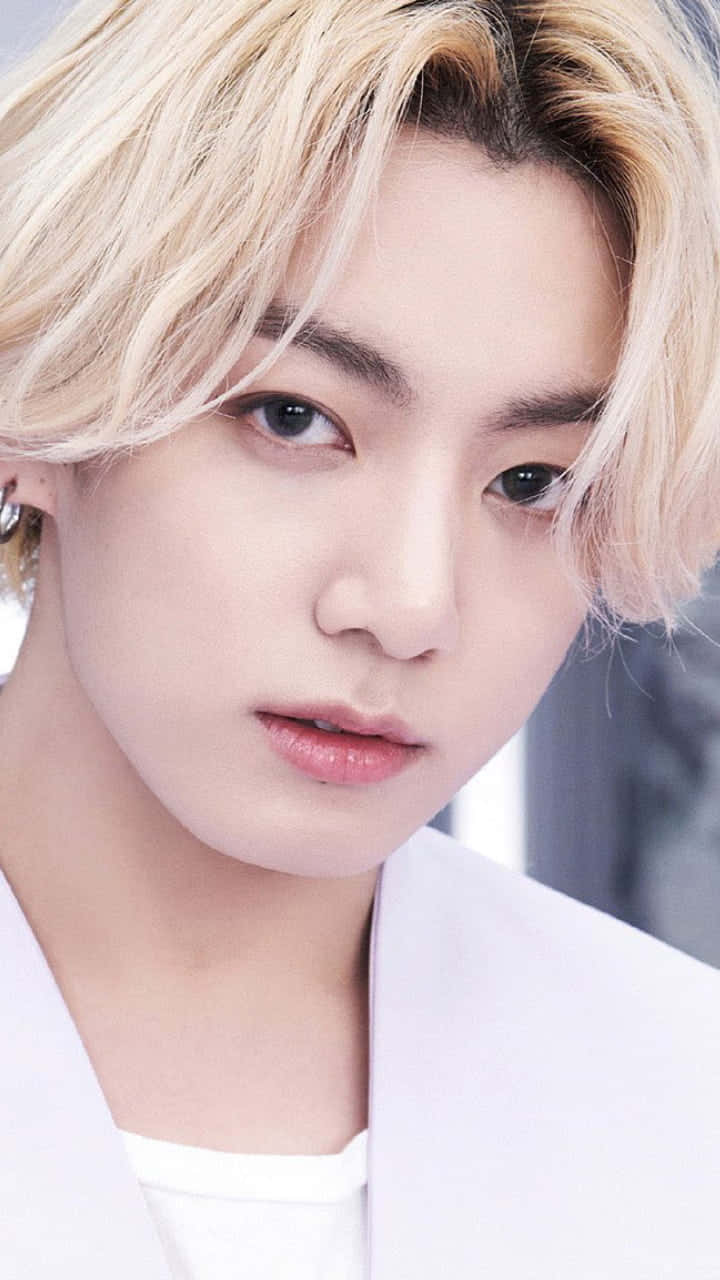 Jungkook於休閒服裝中展現自信魅力 壁紙 — 年輕男子近距離肖像照，一頭鉑金色頭髮，眼神銳利，身穿白色西裝外套。