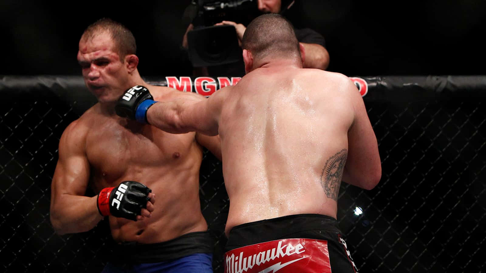 兩名男性拳手在MMA籠鬥中，其中一人揮拳