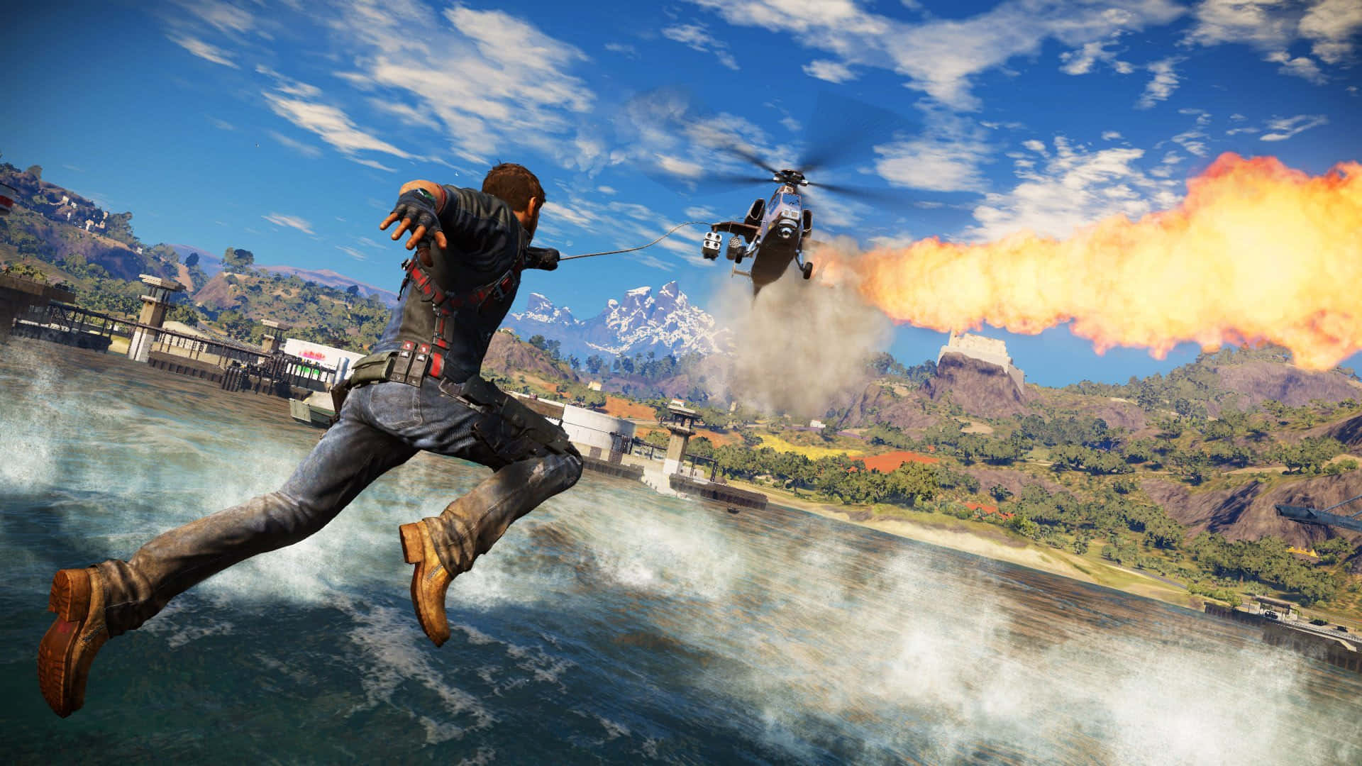 Just Cause 4 1920x1080 背景：火煙 壁紙 — 一名男子跳過水面，身後有直升機發射火焰，背景為山巒。