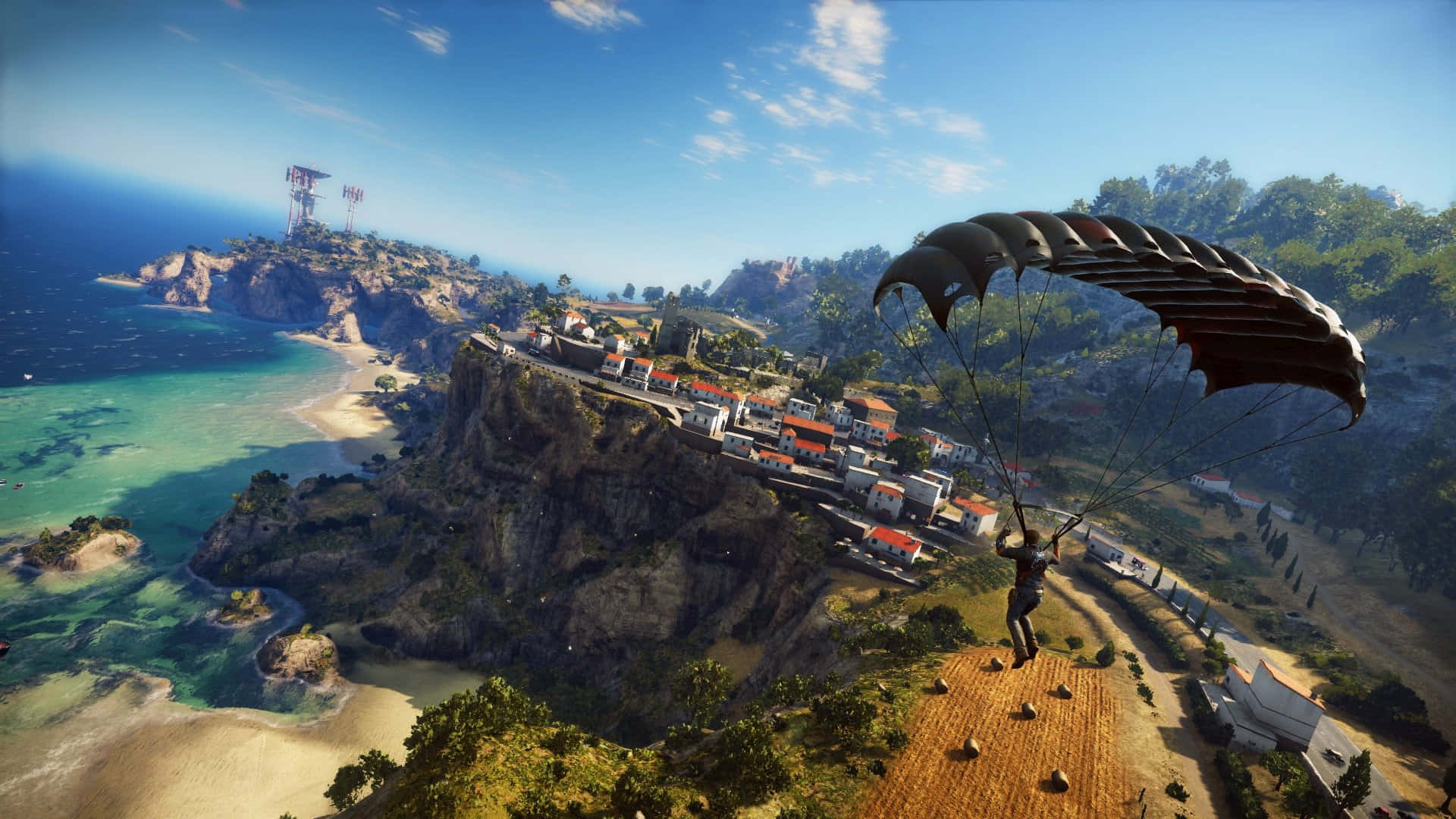 Just Cause 4 1920x1080 背景：降落傘 壁紙 — 一名跳傘者正在明亮的藍天下，降落在一個擁有碧綠海水和紅瓦屋頂的沿海懸崖村莊上空。