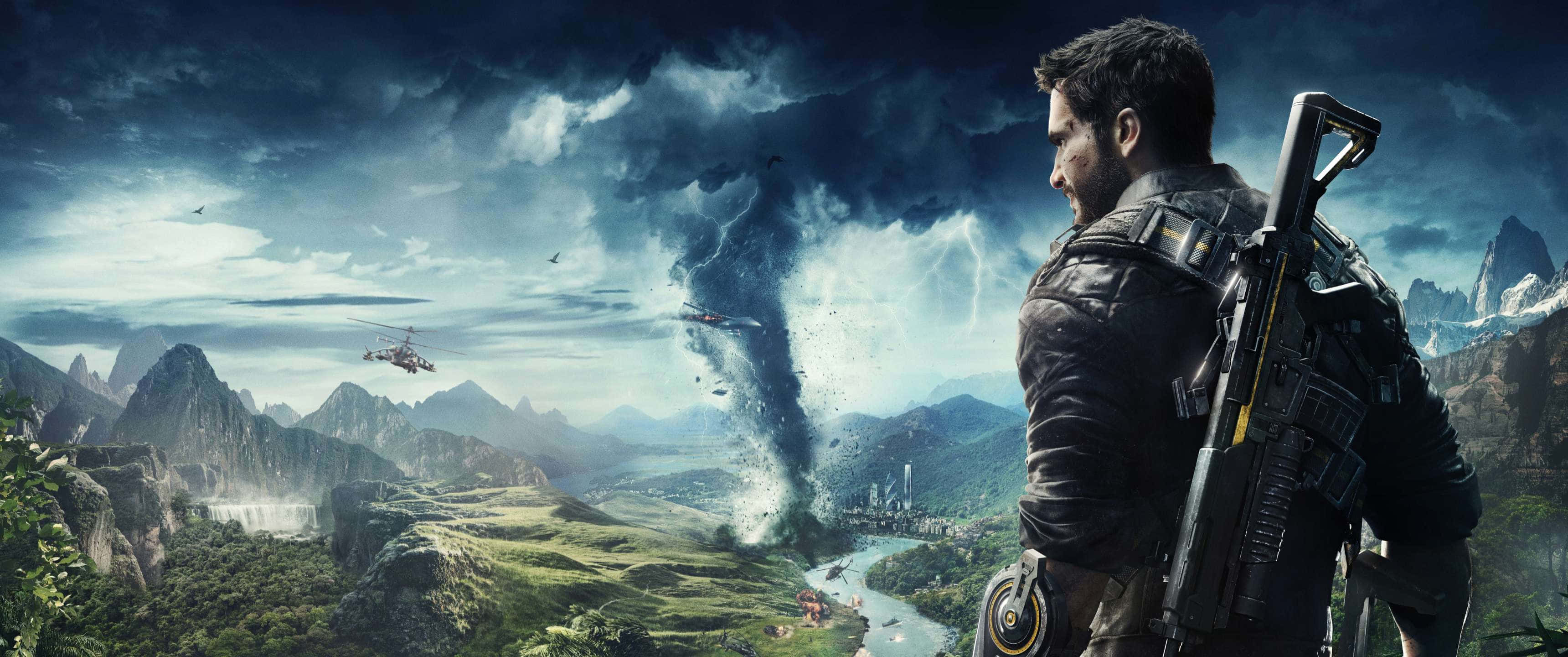 《Just Cause 4》危險龍捲風場景 3440x1440p 壁紙 — 一名持步槍的士兵俯瞰山谷，直升機在鋸齒狀山脈上空靠近巨大龍捲風飛行。
