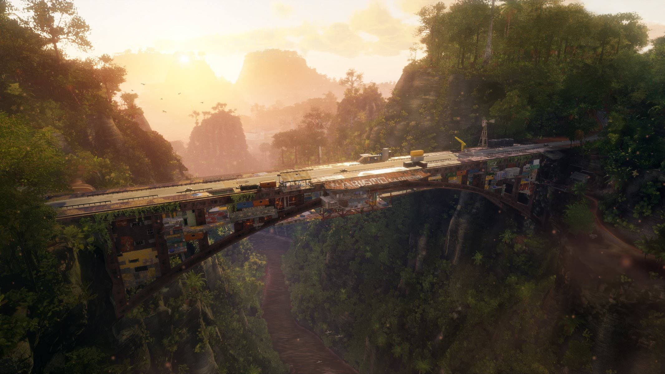 Just Cause 4 橋樑 壁紙 — 一個充滿活力的日落沐浴著一座橫跨茂密峽谷的危險橋樑，一列繁忙的火車載著色彩繽紛的貨物穿過霧氣繚繞的叢林山峰。