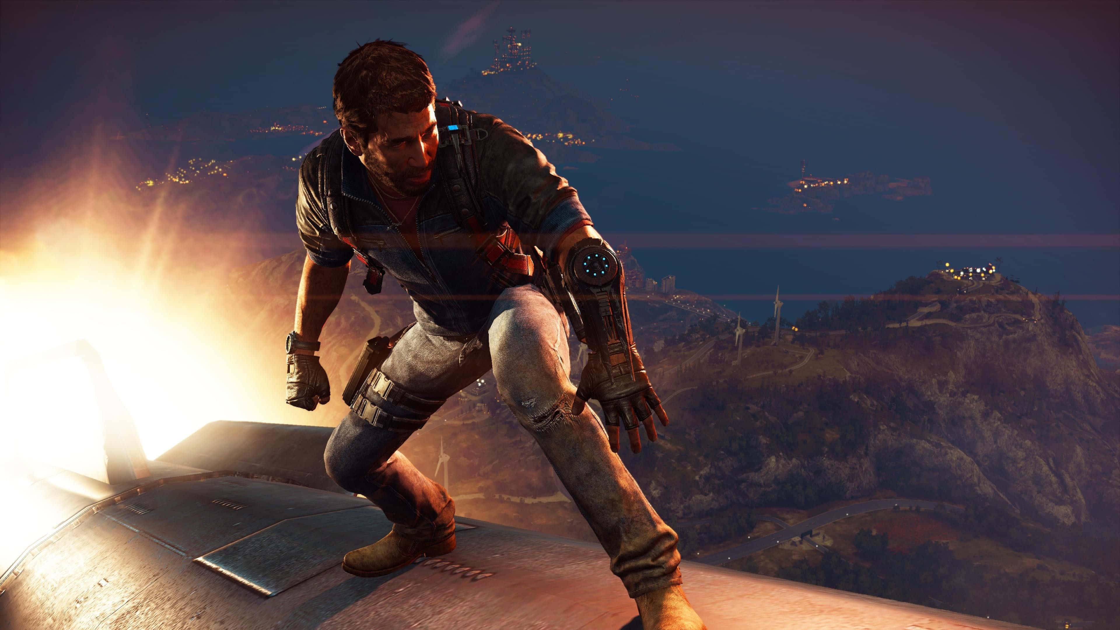 《Just Cause 4》背景：里科站在行進中的火車頂上 壁紙 — 一個粗獷的男人在黃昏時蹲在車頂上，遠處的城市景觀閃爍著光芒。