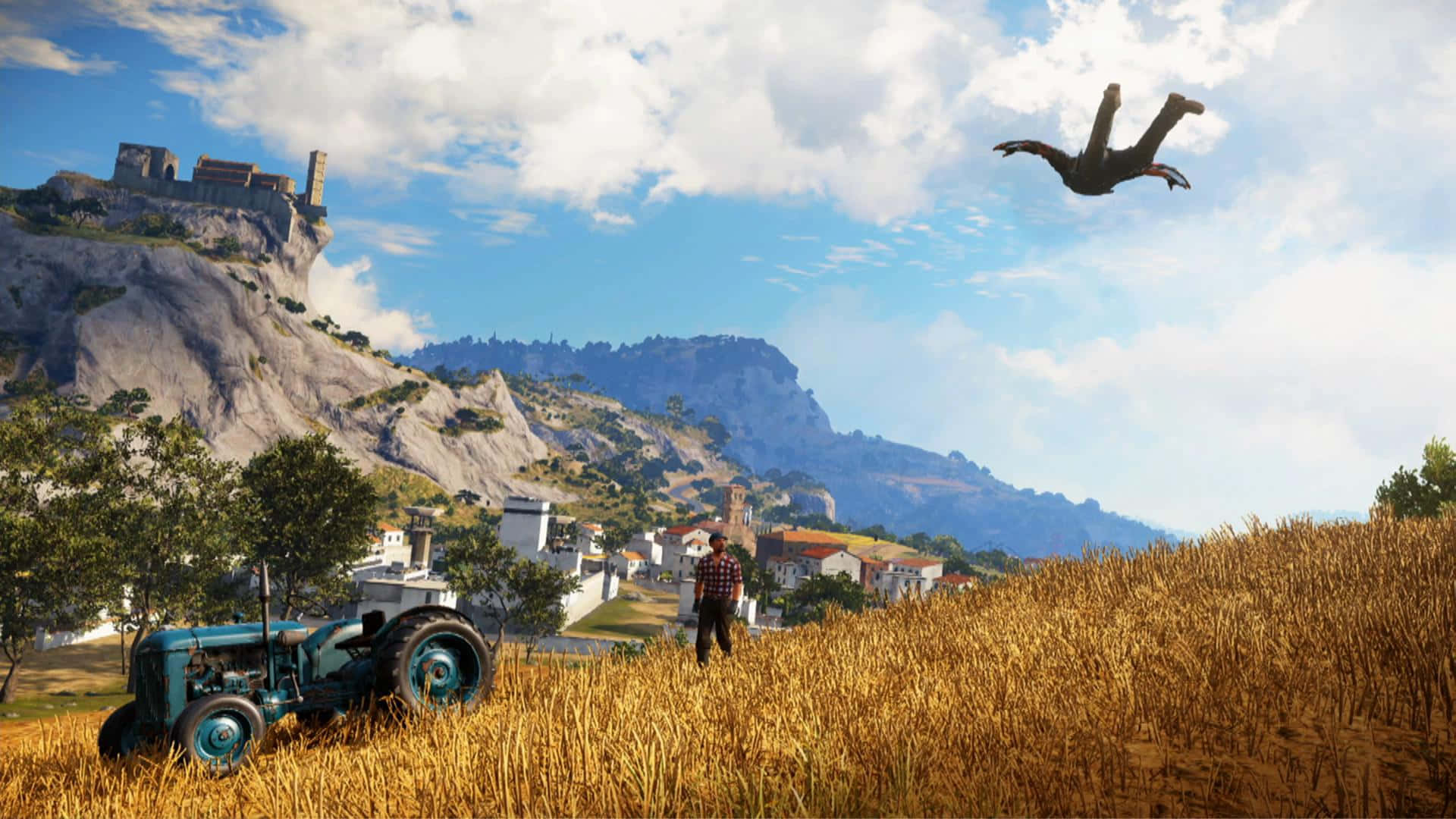 《Just Cause 4》背景：里科飛越農田 壁紙 — 一位農夫站在金色麥田裡，旁邊有一輛復古藍色拖拉機，一個人影飛過明亮的藍天，下方是山坡村莊和城堡。