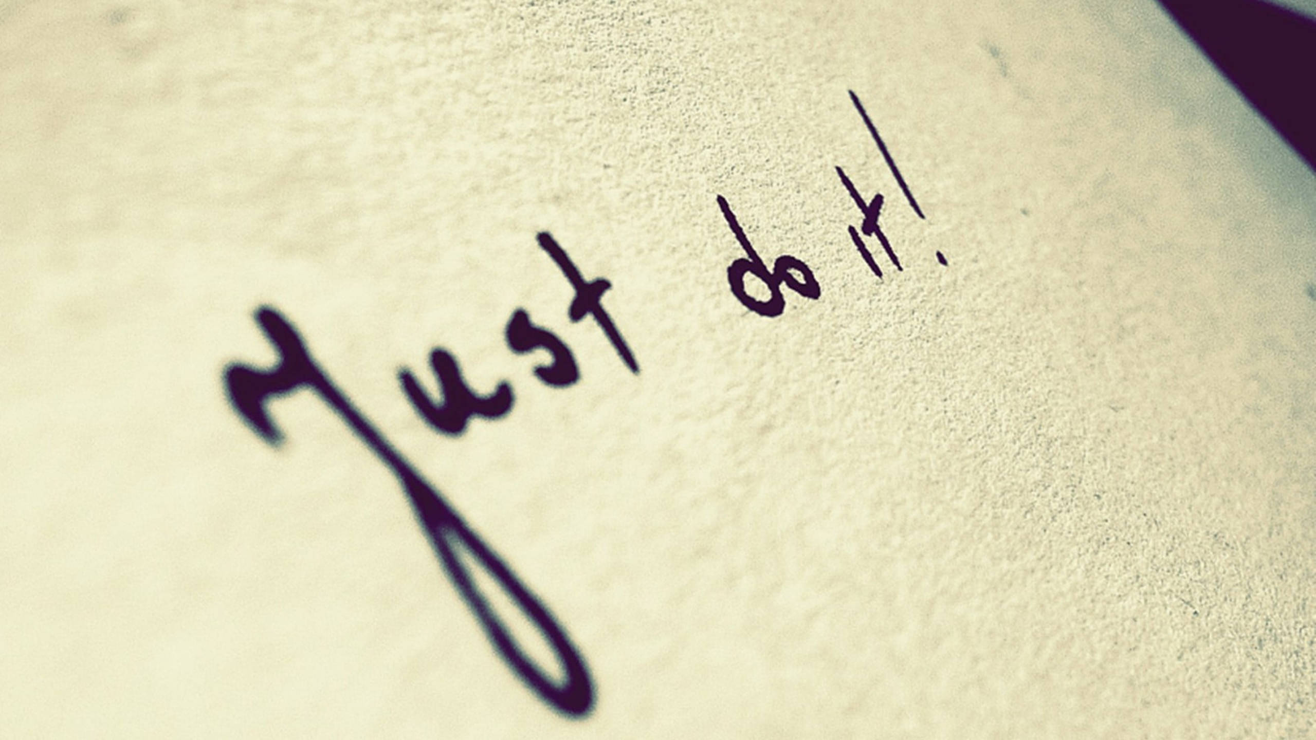 Just Do It 文字特寫壁紙 壁紙 — 在紋理米色紙張上用粗體墨水手寫的勵志短語 just do it，淺景深。