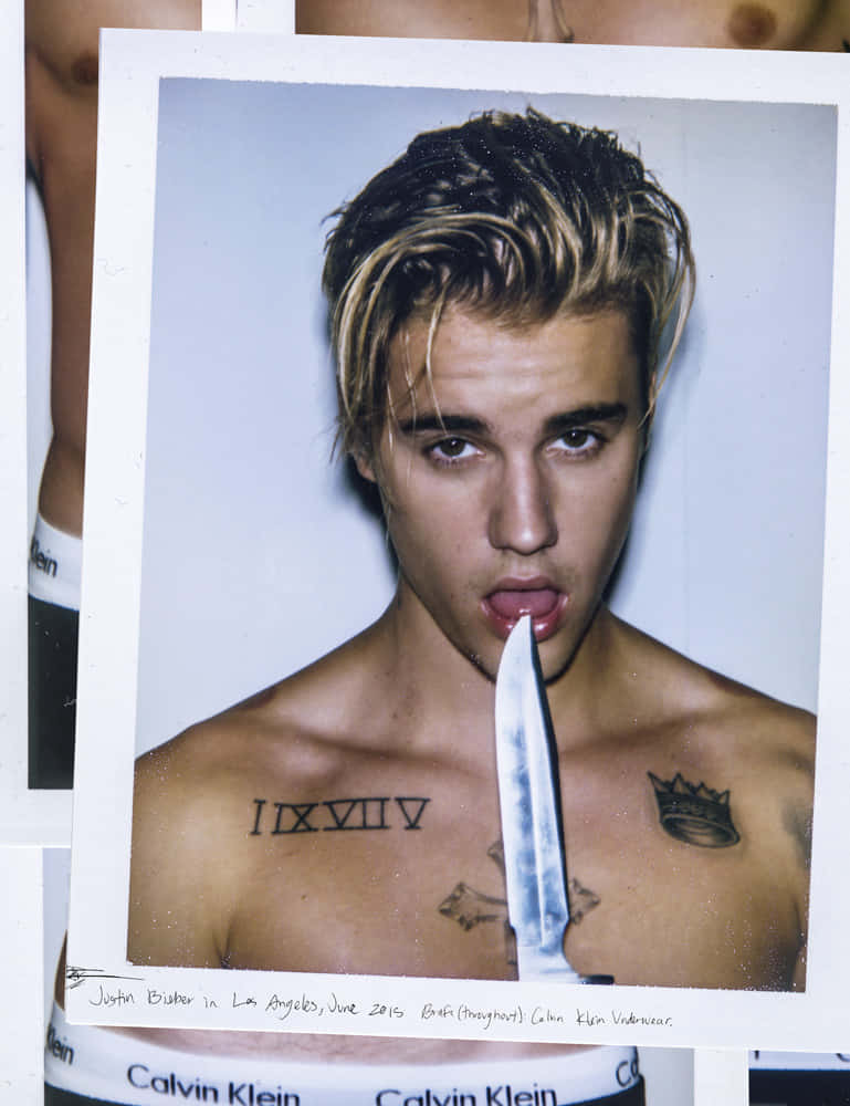Justin Bieber在工作室照片中將刀放在嘴唇上。