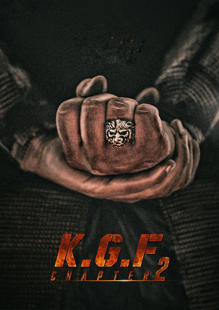 一隻握緊的拳頭戴著獅子戒指，被另一隻手握住，電影《KGF 第2章》海報。