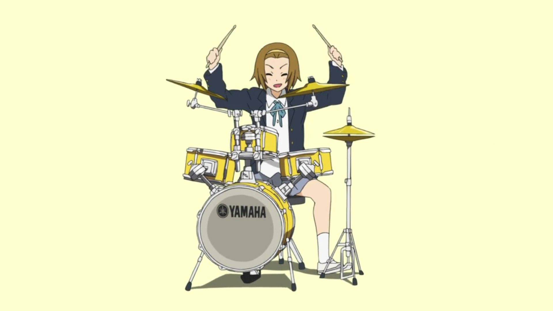 K-on! 鼓手平澤唯熱情演出 壁紙 — 一個開心的動畫女學生穿著校服，在淡黃色背景前充滿活力地演奏黃色 Yamaha 鼓組。