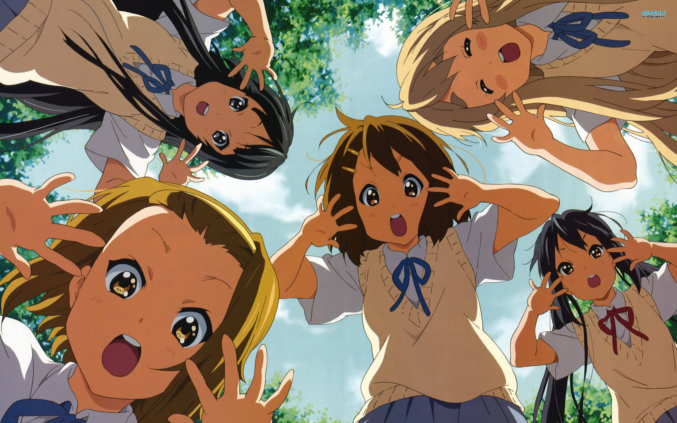 K-on 女孩穿校服 壁紙 — 四個穿著校服的動漫女孩在明亮的藍天和綠樹的襯托下，開心地伸出雙手圍繞著觀眾。
