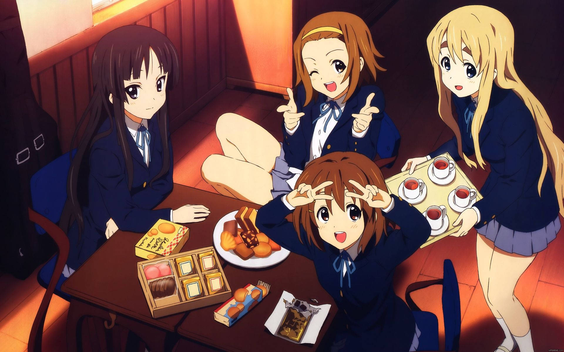 K-on 學校茶點時光 壁紙 — 四個穿著校服的動漫女孩聚集在一張擺滿甜點和茶的桌子周圍，房間是木質的，燈光溫暖。