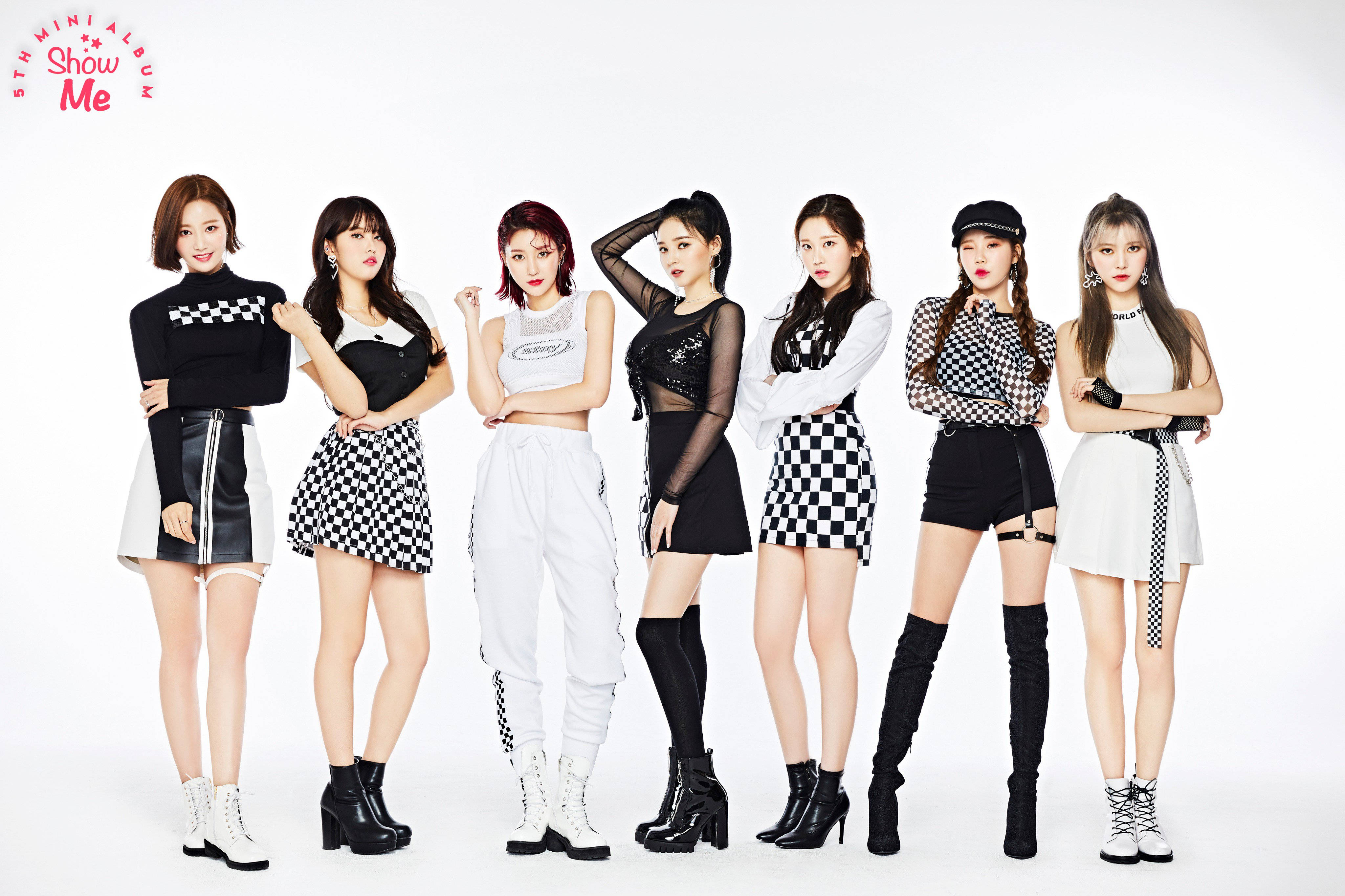 K-Pop 南西 Momoland 高畫質 壁紙 — 七位時尚女性穿著大膽的黑白格紋服裝，在純白背景前自信地擺姿勢。