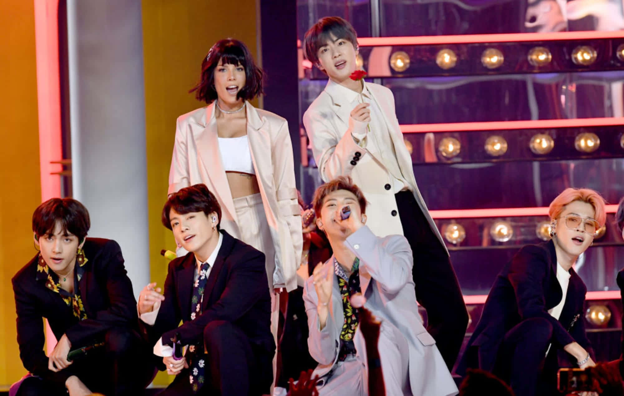 Bts Performance 桌布 壁紙 — K-pop 團體在燈光明亮的舞台上以色彩繽紛的燈光和動感姿勢充滿活力地表演。