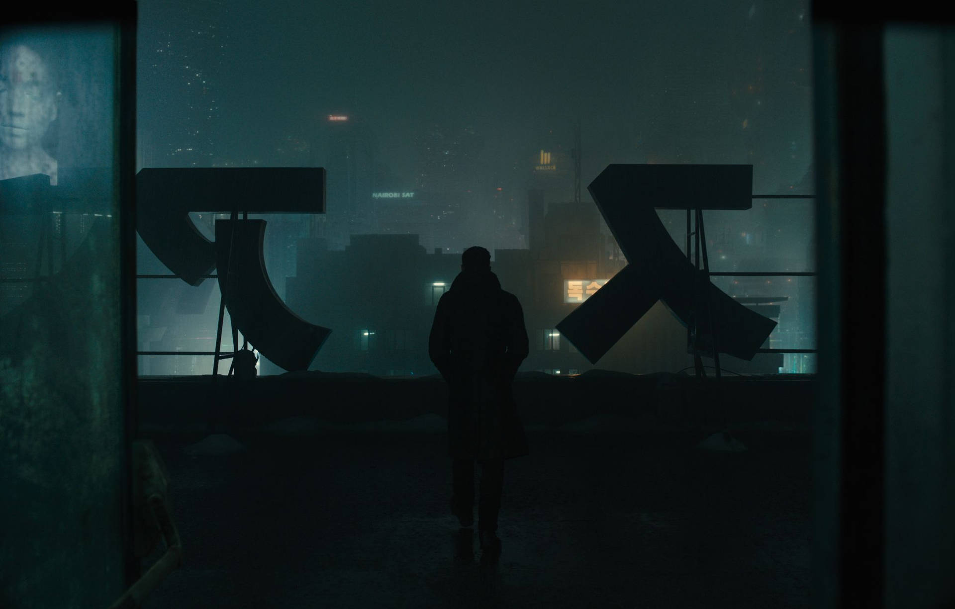 一個人站在下雨的屋頂上，俯瞰夜晚發光的城市的剪影。
