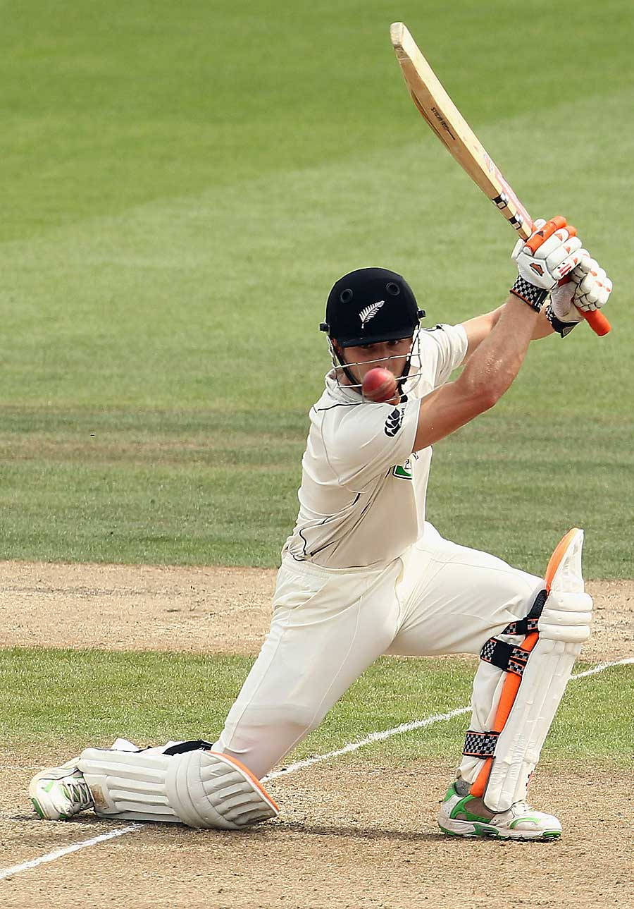 Kane Williamson 擊球姿勢 壁紙 — 一名身穿白色球衣的板球擊球手在綠色場地上揮動球棒擊打紅色球。