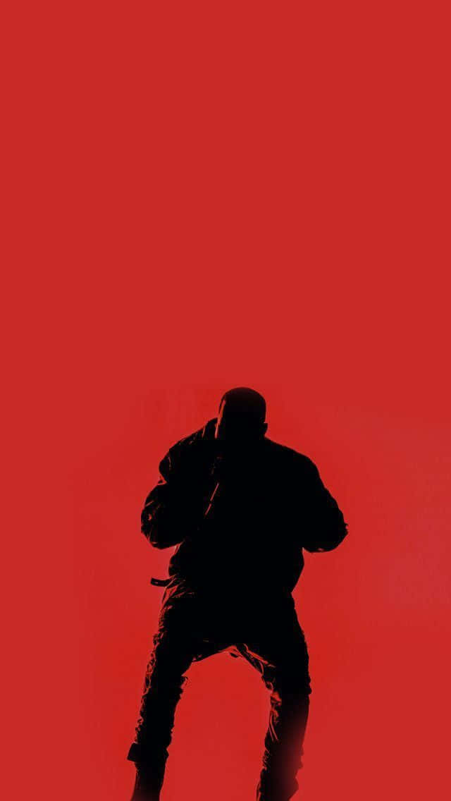 Kanye West 獨家 iPhone —— 對經典 Apple 手機的革命性演繹 壁紙 — 一個人在鮮紅色實色背景上蹲伏姿勢的鮮明黑色剪影。