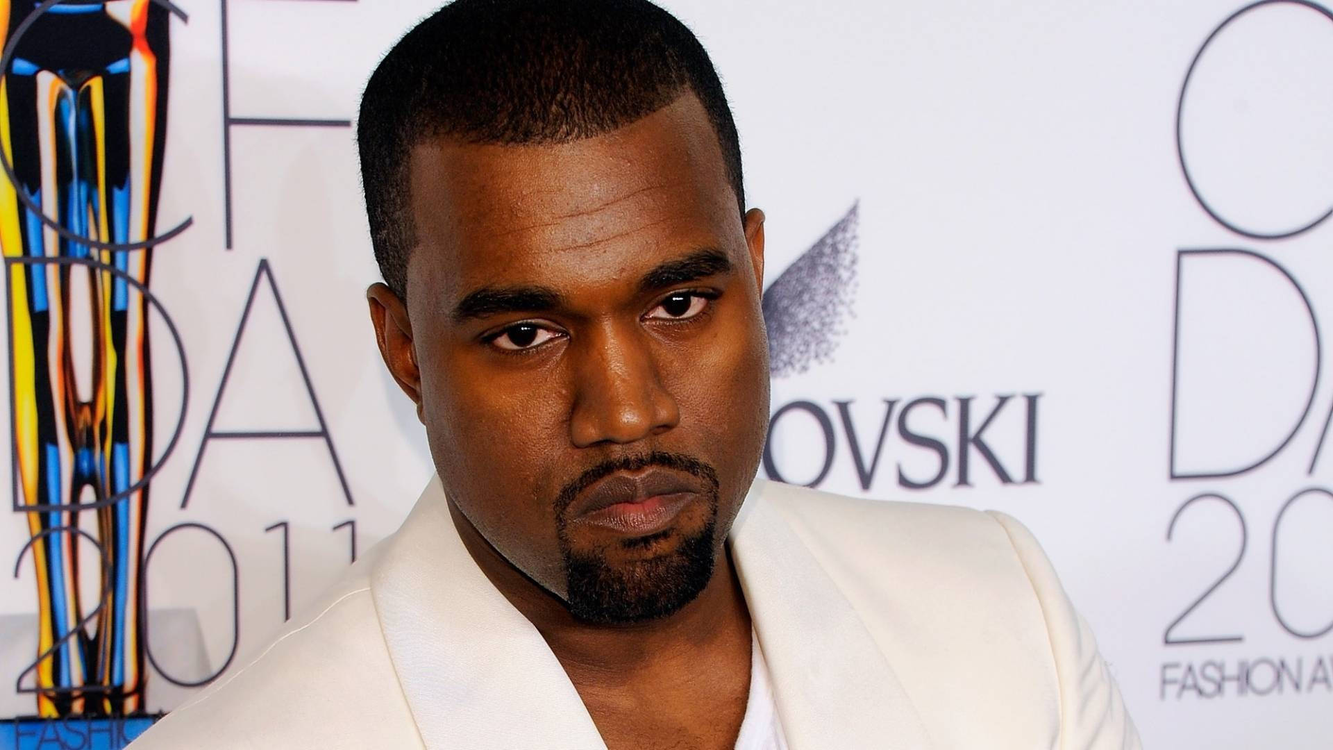 Kanye West 在2011年時尚頒獎典禮上身穿白色西裝，表情嚴肅。 — 美學白色動態圖 壁紙