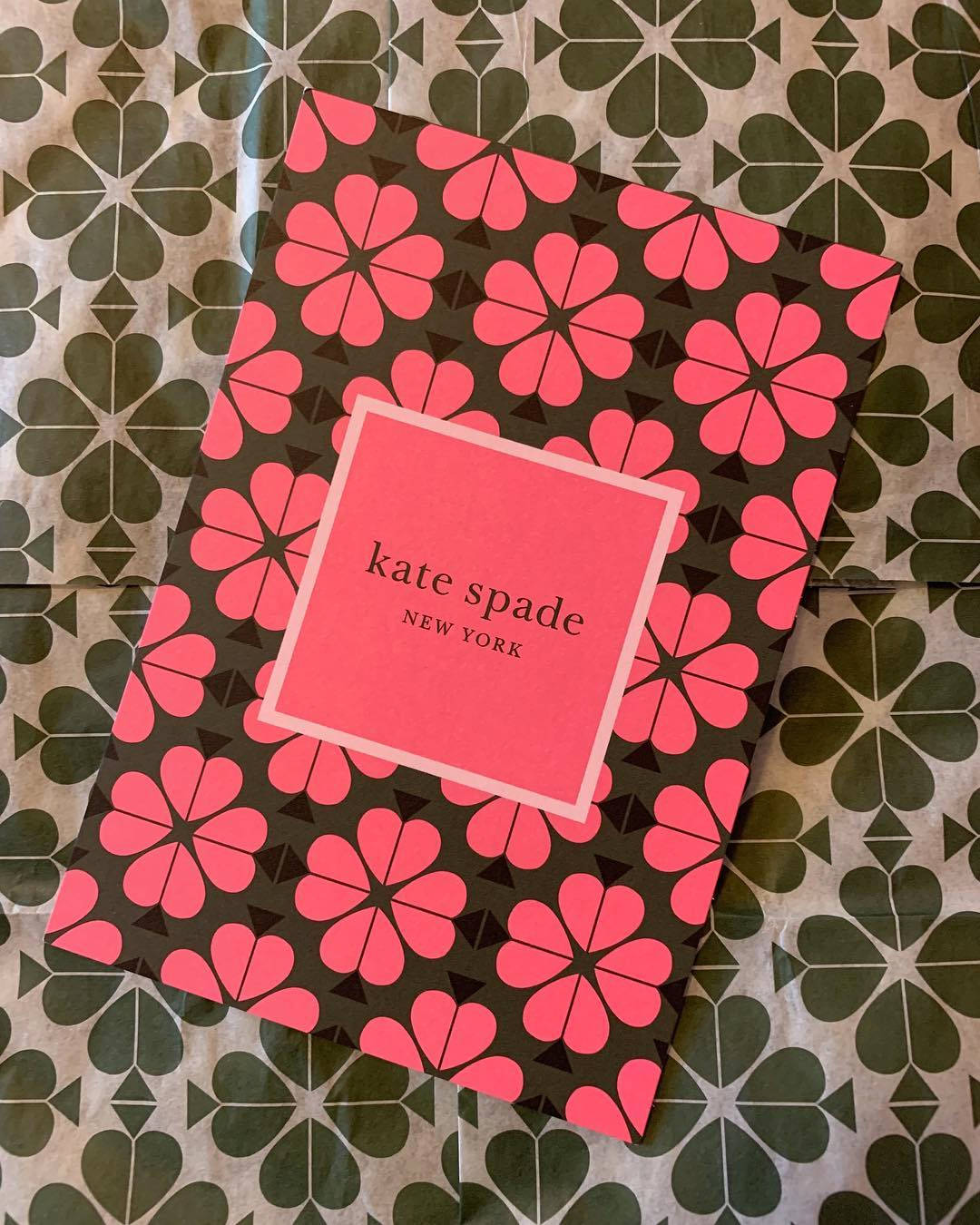 粉紅色花卉Kate Spade盒子在綠色圖案背景上
