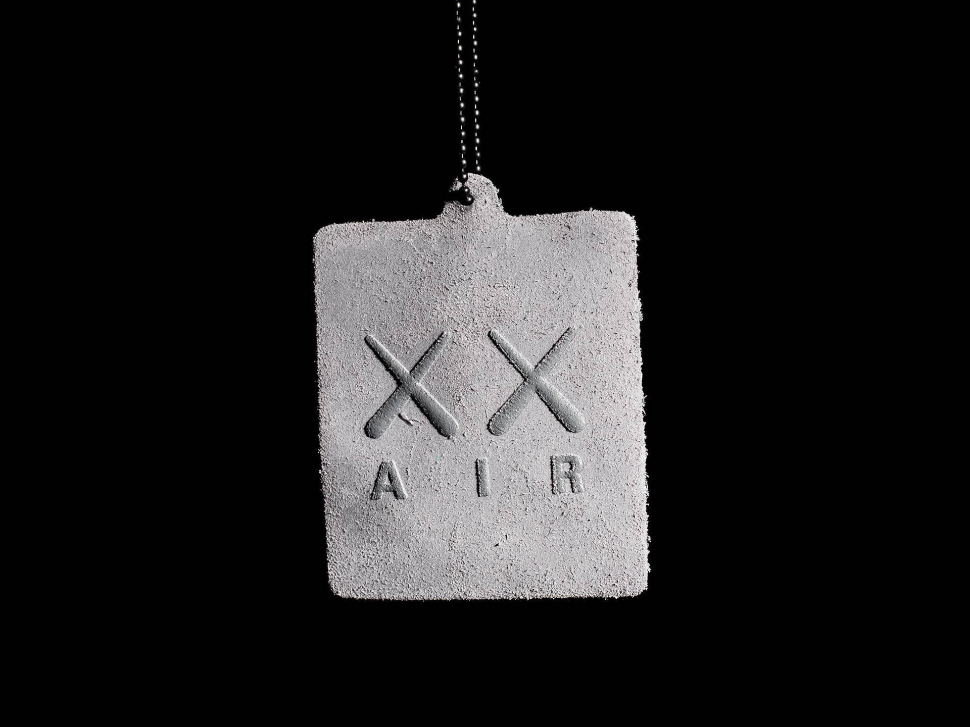 混凝土標籤，帶有「XX AIR」文字，用鏈條懸掛在黑色背景上