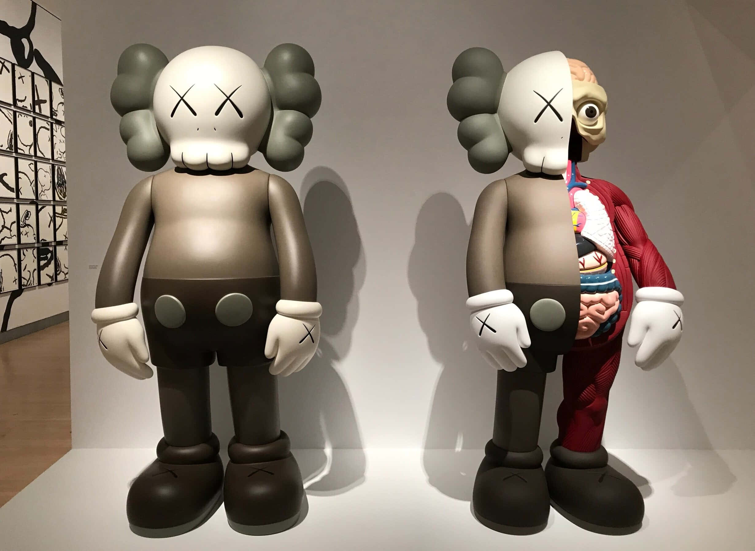 KAWS x Uniqlo UTⓇ 2020 系列 壁紙 — 兩件大型KAWS雕塑並排而立，一件完整無缺，另一件在畫廊環境中顯露內部器官。