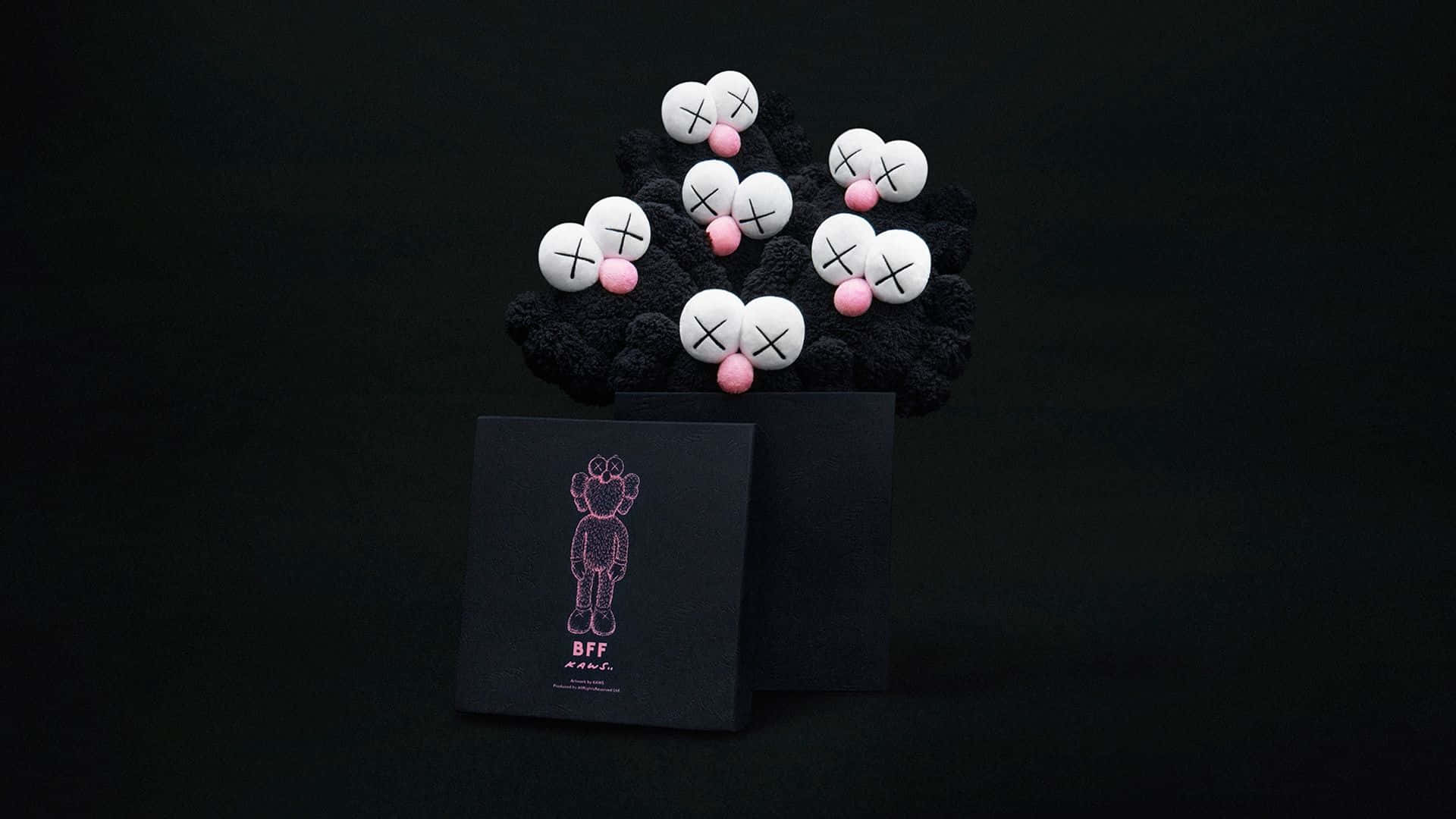 KAWS——標誌性藝術家與玩具設計師 壁紙 — 一群白色KAWS風格毛絨公仔，粉紅色鼻子，放在黑色底座上，旁邊有一個黑色盒子，上面有粉紅色KAWS角色插圖。