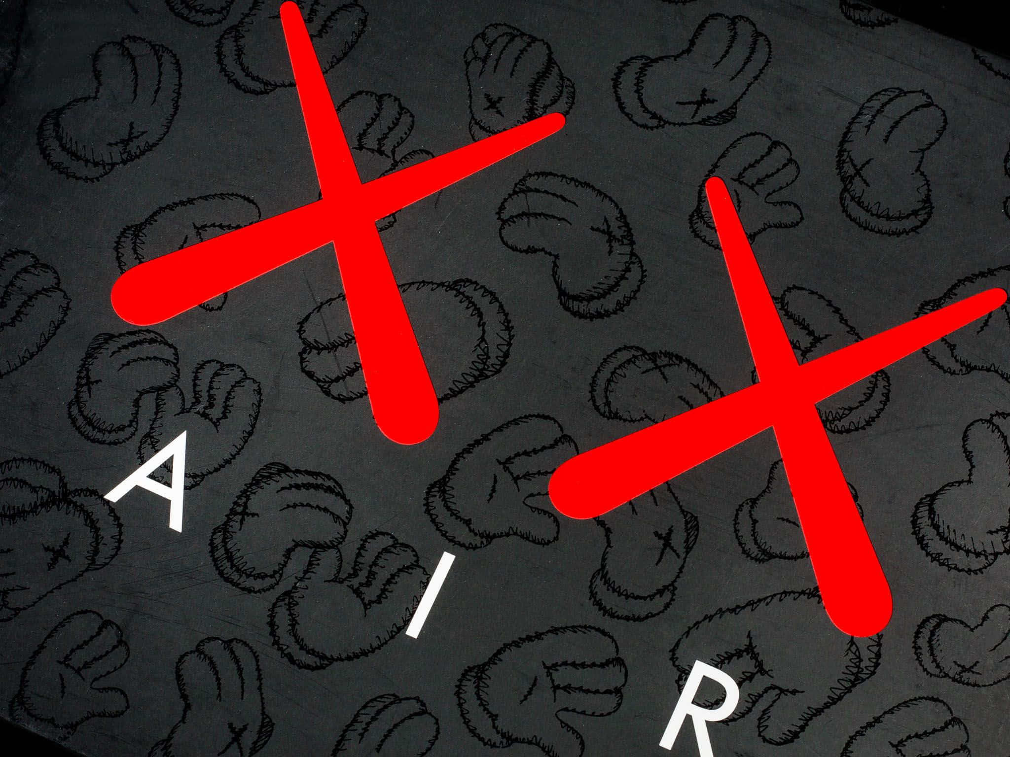 KAWS，當代經典藝術家 壁紙 — 大膽的紅色十字架和白色字母在深灰色布料上拼出'AIR'，布料上帶有縫製的卡通拳頭圖案。