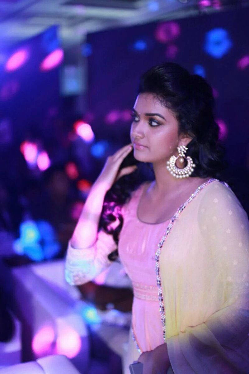 在色彩繽紛的夜間派對中，身穿傳統服飾的女性，伴隨著閃爍的燈光。