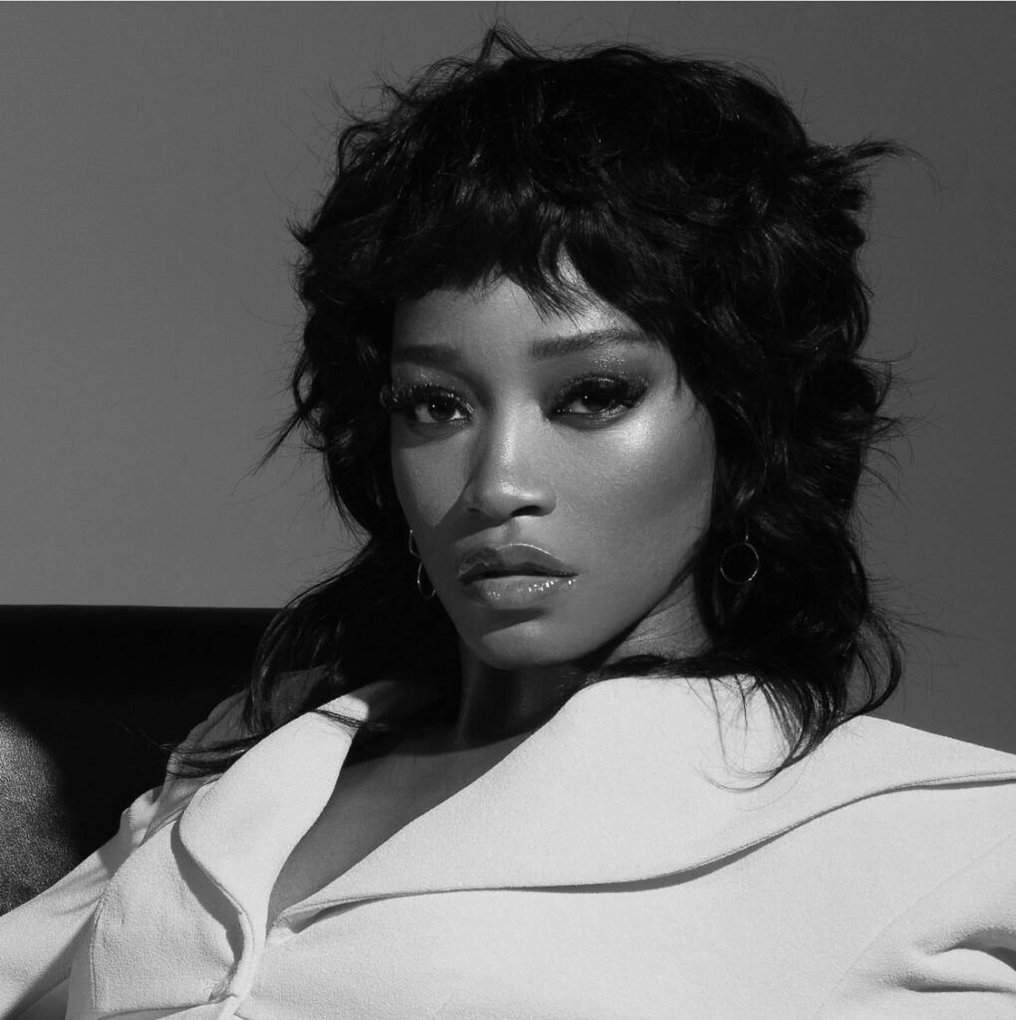 Keke Palmer 黑白風 壁紙 — 一個引人注目的黑白肖像，一位擁有豐盈捲髮和大膽妝容的女性直視鏡頭。