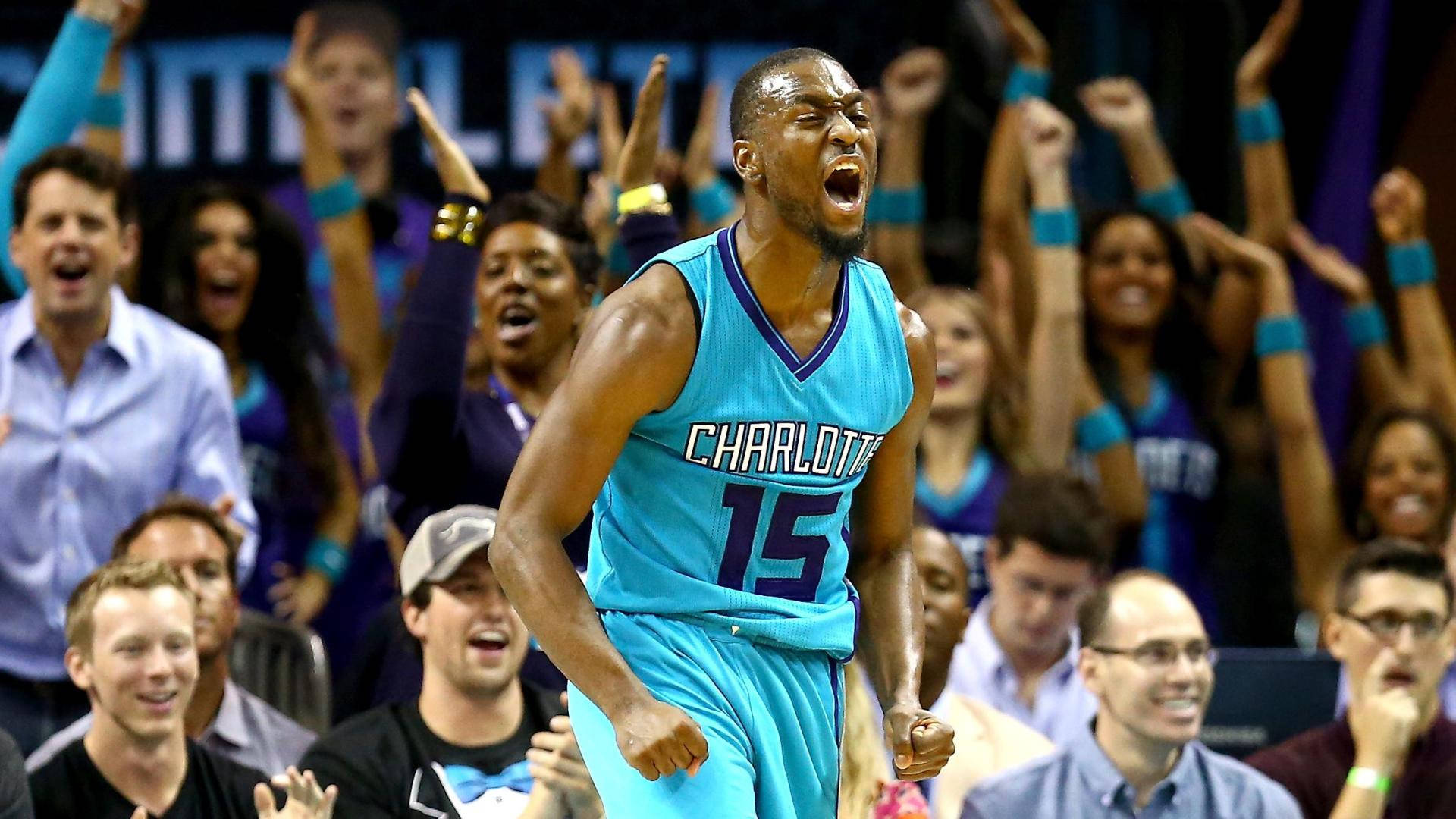 Kemba Walker 夏洛特對戰薩克拉門托 壁紙 — 一位身穿青綠色球衣的夏洛特黃蜂隊籃球運動員發出勝利的吼叫，背景中的球迷舉起拳頭歡呼。