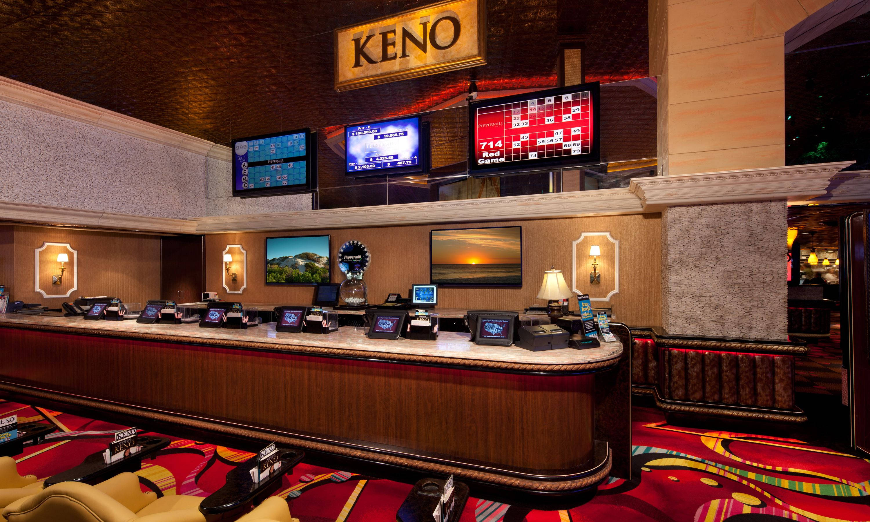 Keno Counter Casino 壁紙 — 豪華賭場基諾櫃檯，配備發光屏幕和華麗木工，在溫暖的環境燈光下。