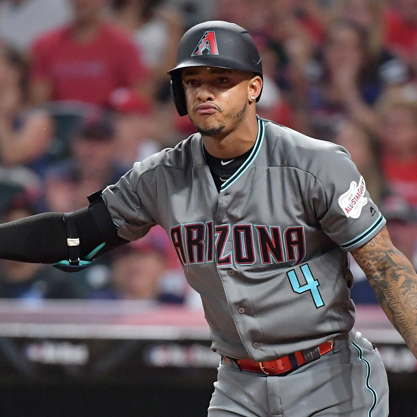 Ketel Marte 吹氣 壁紙 — 身穿灰色亞利桑那隊4號球衣的棒球選手在夜間比賽中向人群做手勢，扮鬼臉。