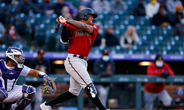 Ketel Marte 空座位 壁紙 — 一名身穿紅色球衣的棒球手在比賽中強力揮棒，背景有捕手和觀眾。