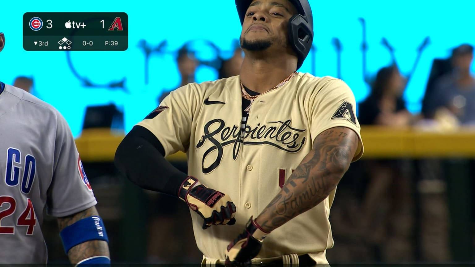 Ketel Marte 跳舞 壁紙 — 穿著金色 'Serpientes' 球衣的棒球運動員在明亮的球場燈光下夜間比賽中在本壘板調整手套。