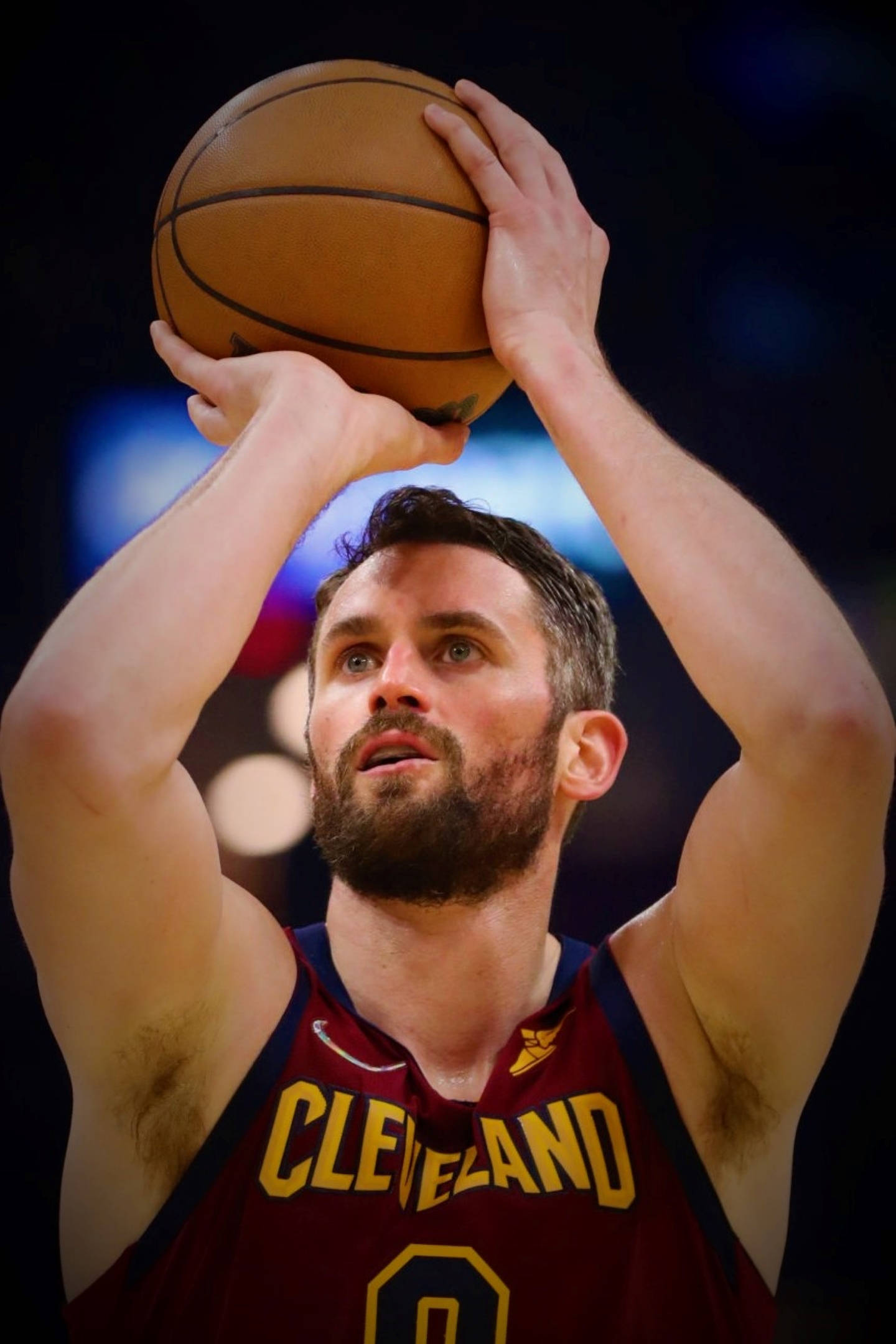 Kevin Love 罰球投籃 壁紙 — 一位專注的籃球運動員身穿克里夫蘭球衣，在場館燈光下準備投籃。