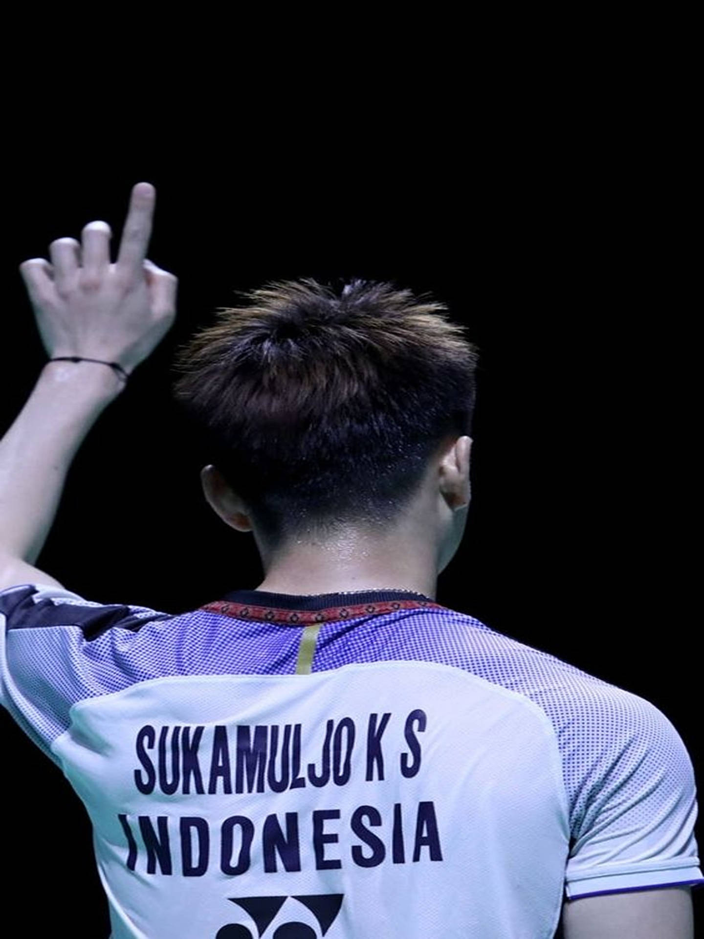 Kevin Sanjaya 高舉手指 壁紙 — 印尼羽毛球運動員Sukamuljo K S的背面，在黑色背景下舉手做出勝利姿勢。