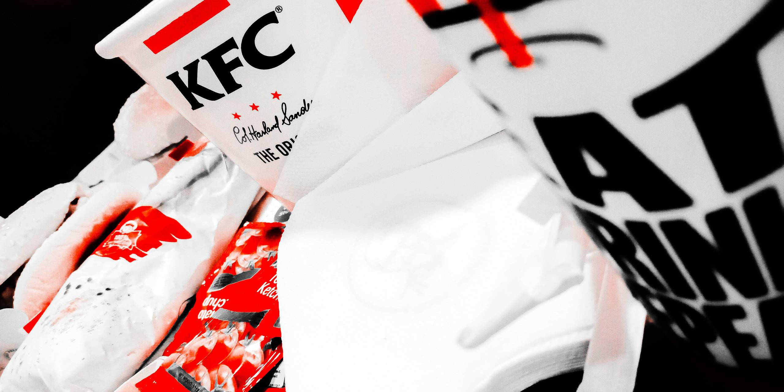 KFC速食套餐 壁紙 — 高對比度近距離拍攝KFC品牌快餐包裝，紅白配色，黑色背景。