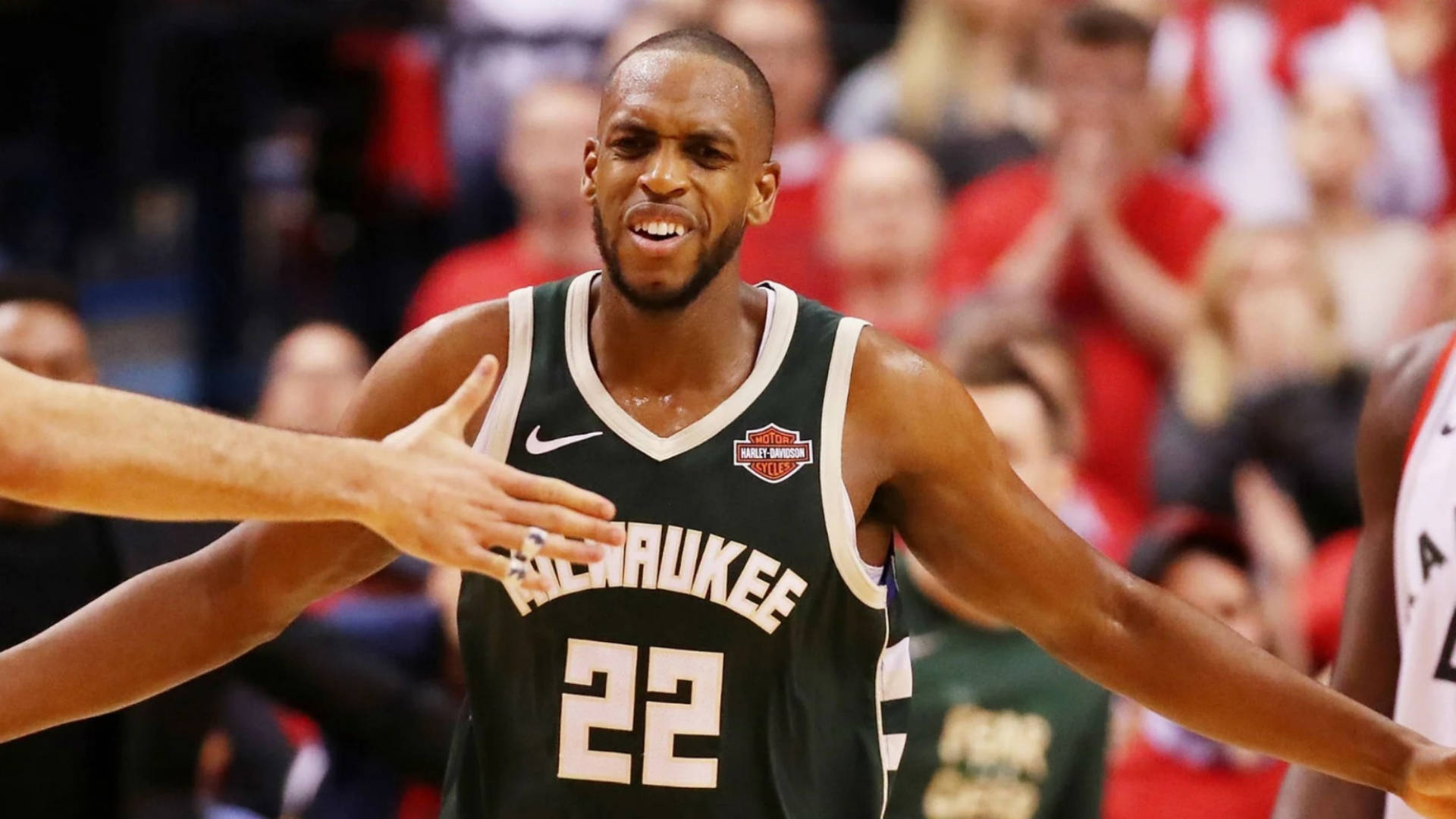 Khris Middleton 熱烈慶祝 壁紙 — 密爾沃基公鹿隊身穿綠色22號球衣的籃球運動員在激烈的比賽中張開雙臂慶祝。