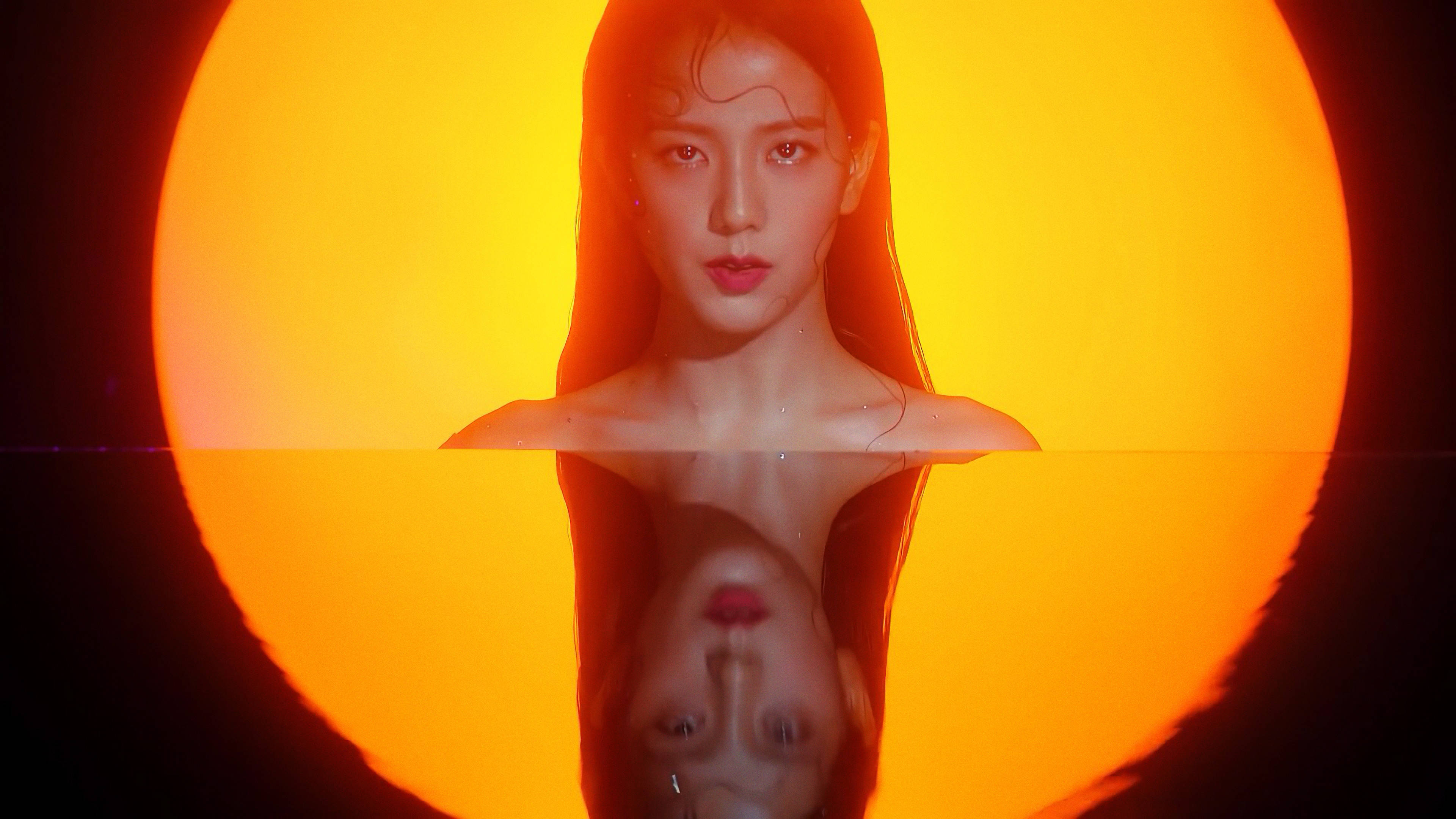 Kill This Love 神仙女神 Jisoo 壁紙 — 一名女性從水中浮現，被發光的橙色太陽框住，下方是她倒置的倒影。