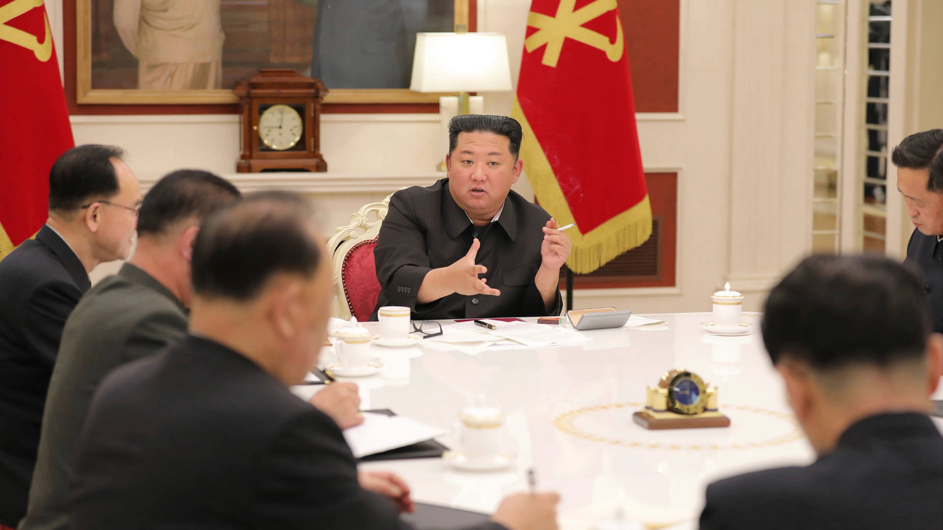 金正恩喺白色枱旁帶領同顧問嘅正式會議。
