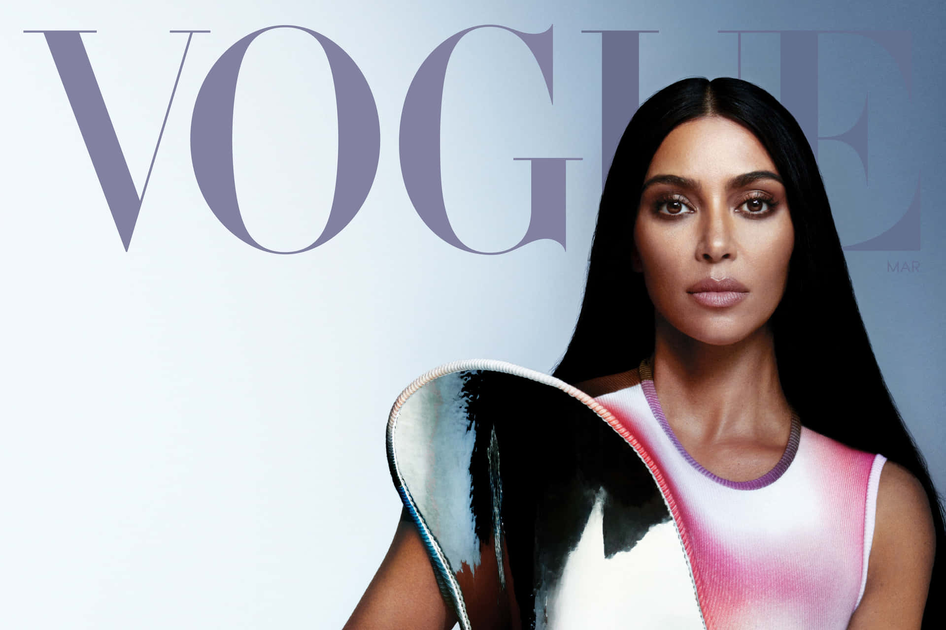  壁紙 — Kim Kardashian 自信地擺姿勢登上Vogue雜誌封面，身穿粉紅色漸變上衣，手持金屬扇子，背景為簡約灰色。
