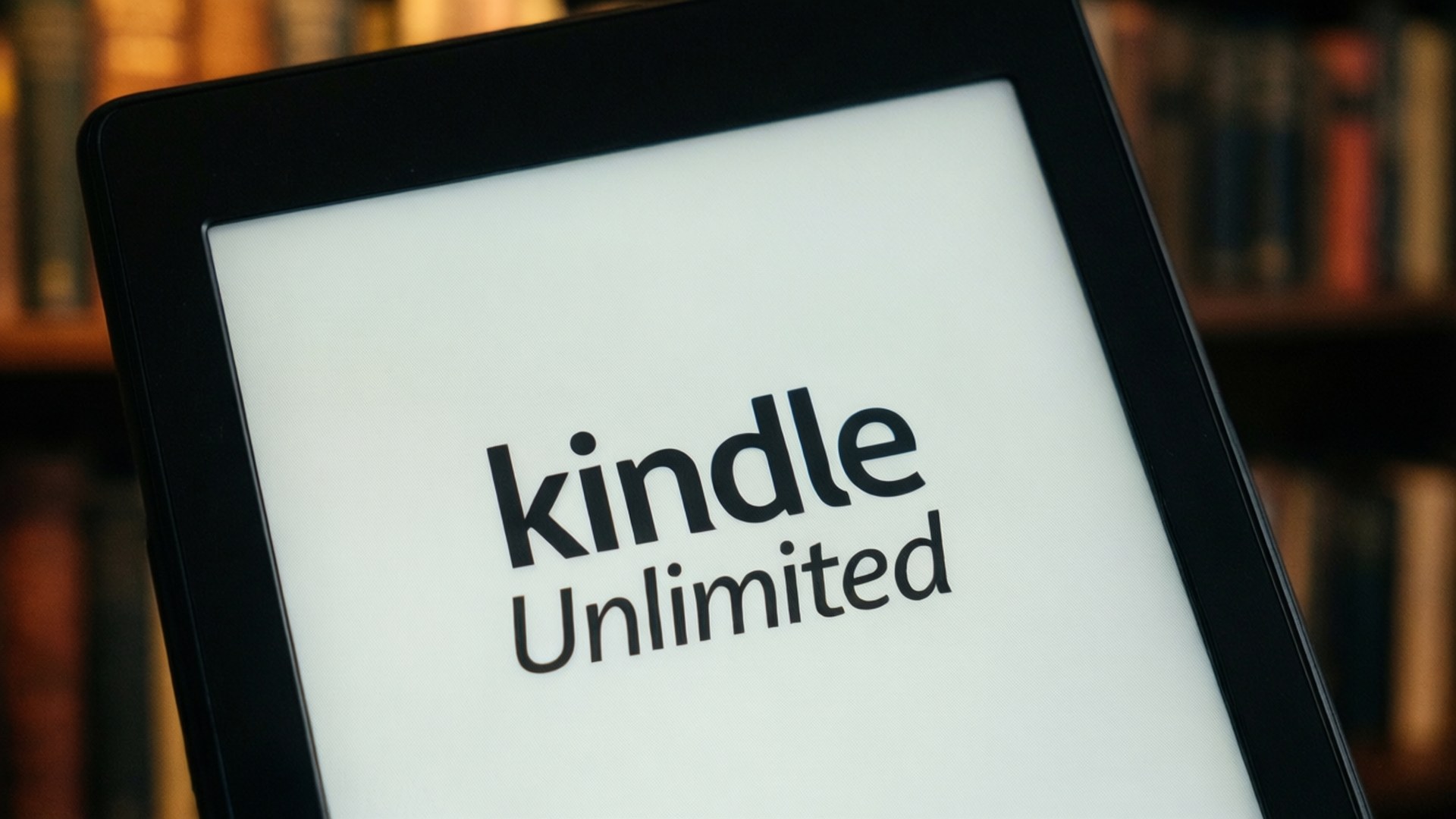 Kindle Unlimited 標誌顯示在平板電腦上，背景為書架。