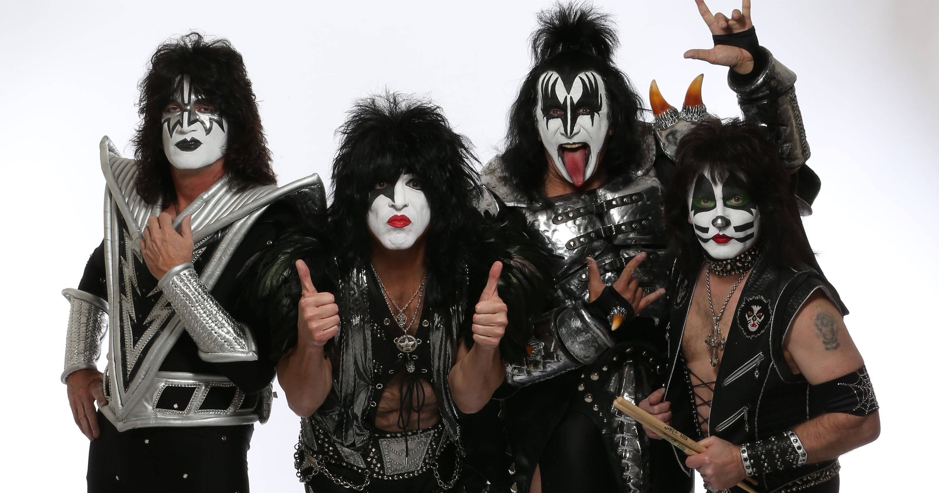 Kiss樂隊成員 posing 壁紙 — 四位標誌性搖滾音樂家身穿精緻的黑色和銀色服裝，帶有標誌性面部彩繪，在純白色背景前自信地擺姿勢。