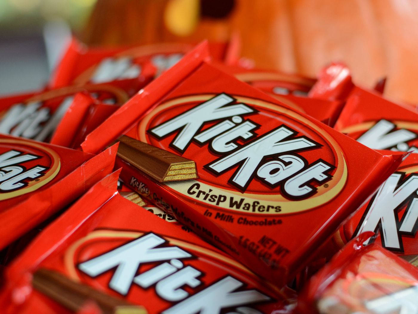 KitKat 薄脆餅乾 壁紙 — 一組鮮紅色嘅KitKat Crisp Wafers包裝堆疊埋一齊，有塊朱古力威化餅露出嚟嘅特寫。