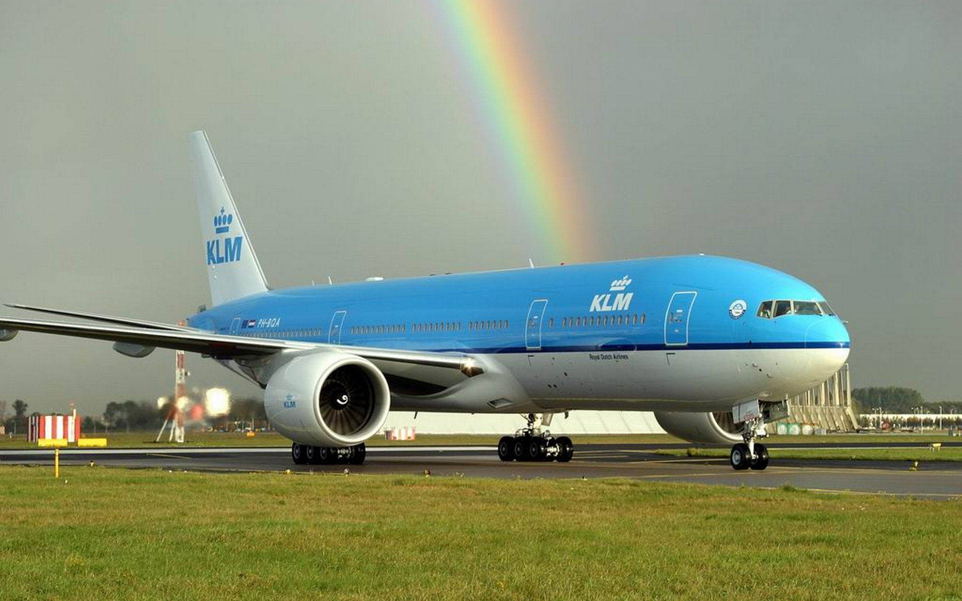 KLM飛機在跑道上，背景有彩虹