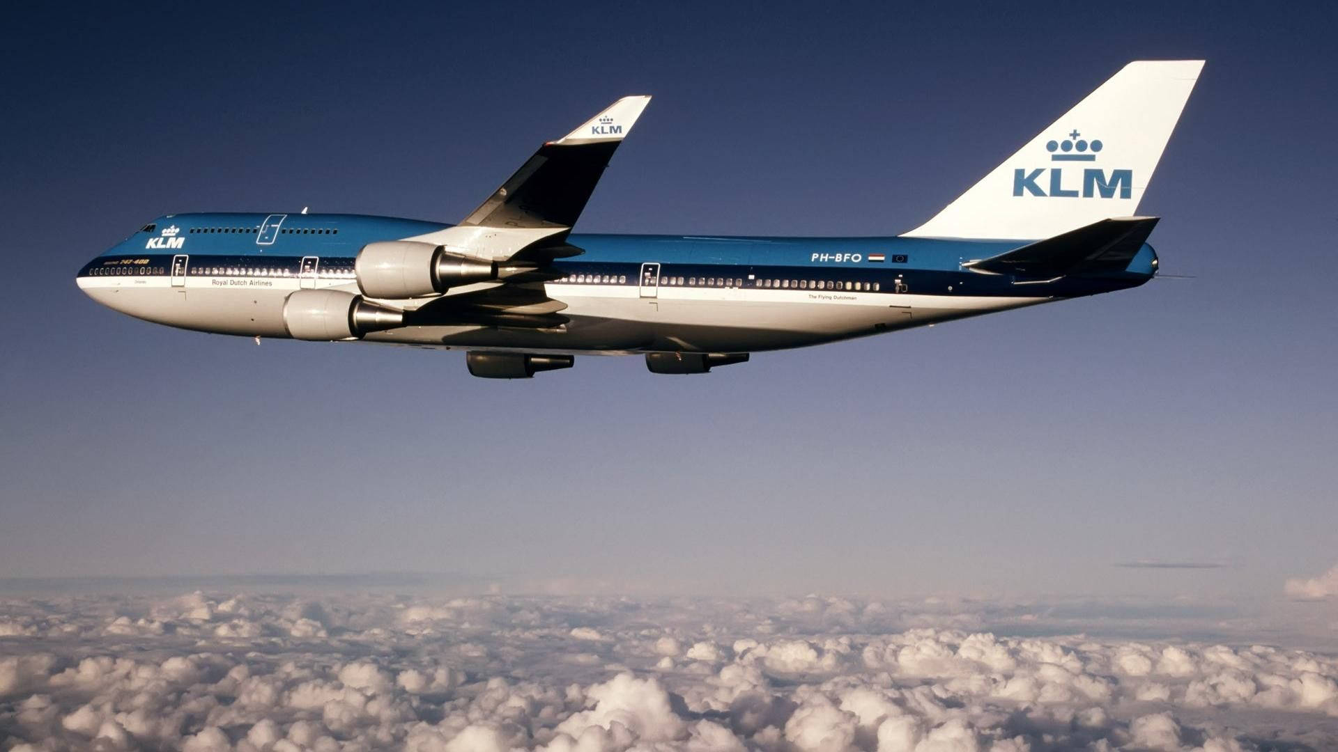 KLM波音747在晴朗藍天的雲層上方飛行