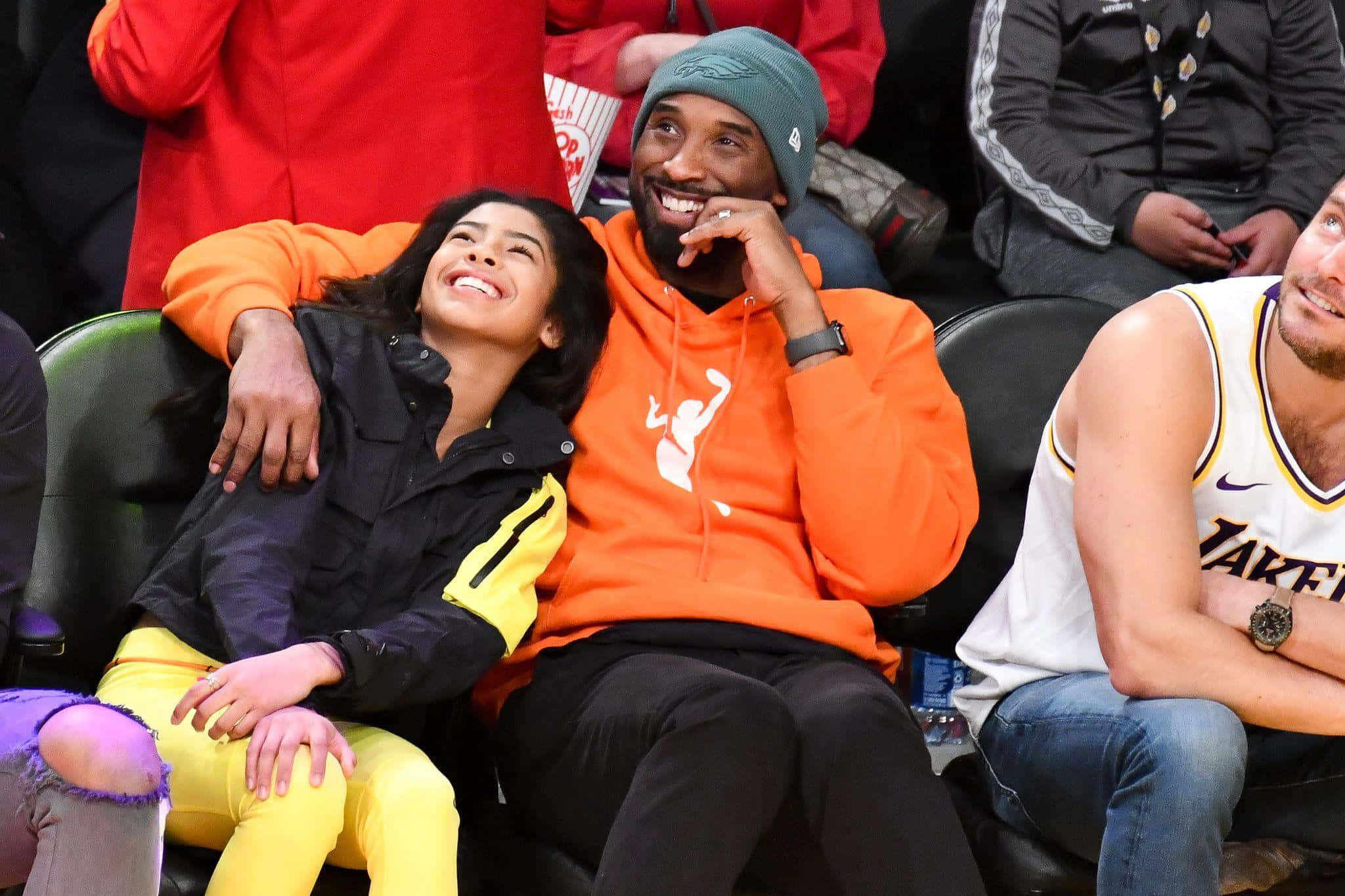 Kobe And Gigi 桌布 壁紙 — 高比拜仁與姬安娜拜仁在湖人隊比賽的觀眾席上一起歡笑，分享快樂時刻。