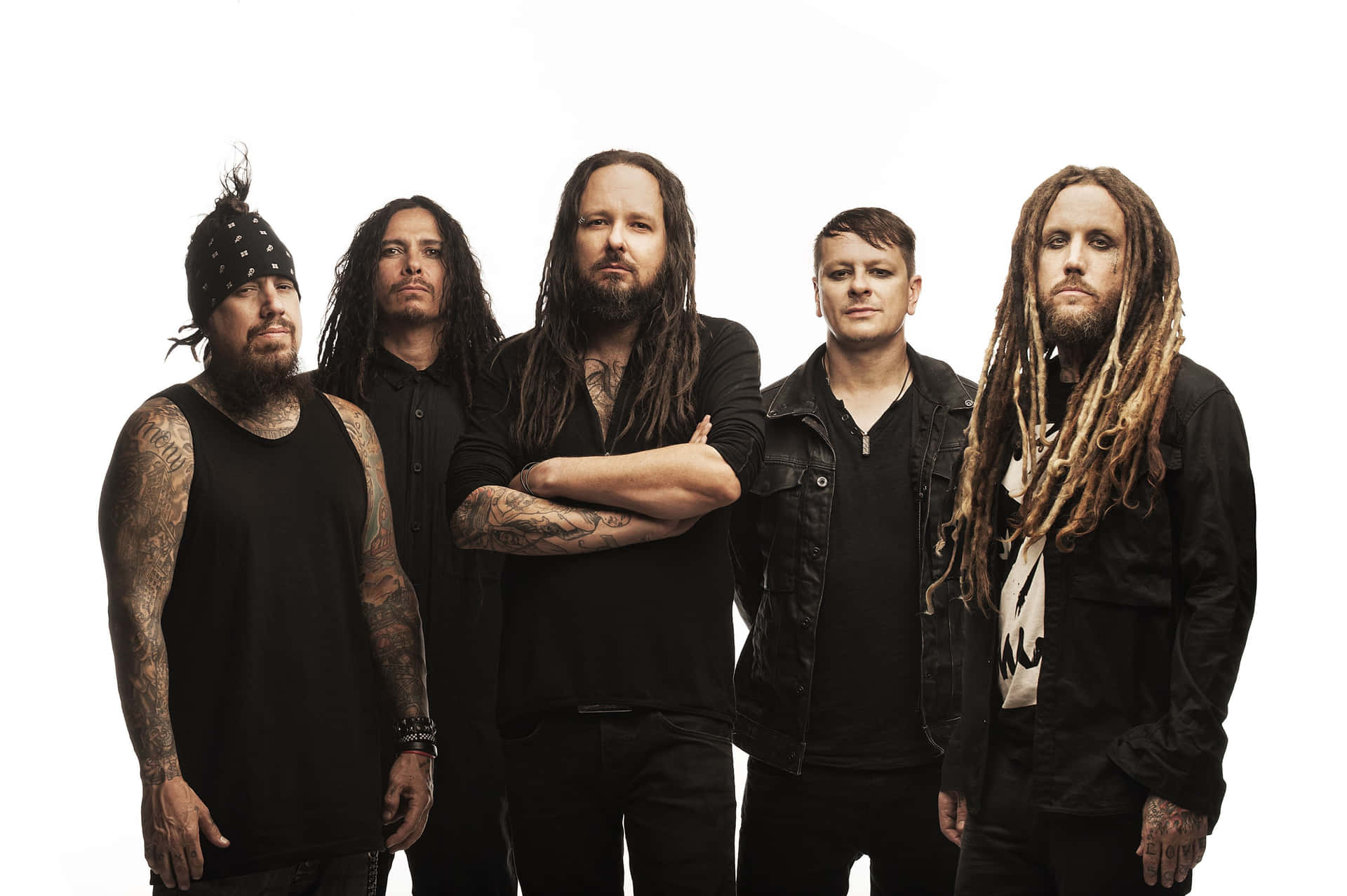 五位紋身長髮男子身穿黑衣在白色背景前嚴肅擺姿勢。 — Metallica GIF 壁紙