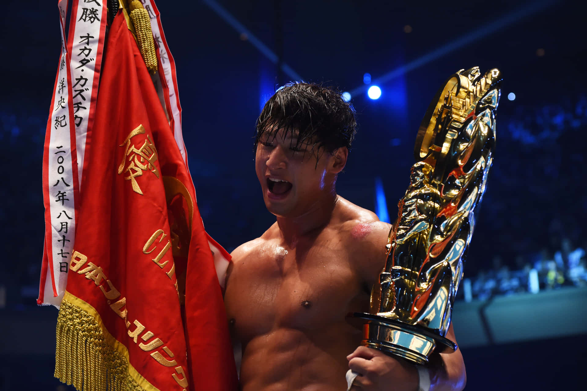 摔角手在比賽獲勝後手持獎盃和旗幟。