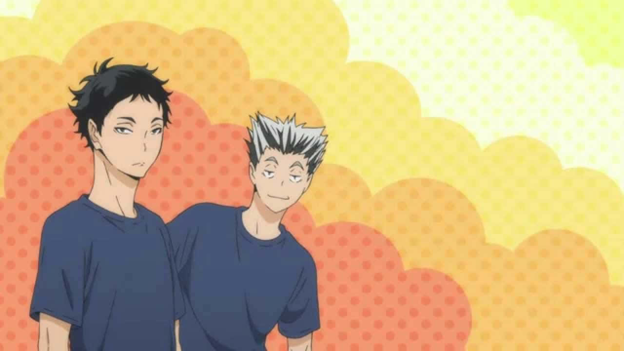 兩個穿著藍色襯衫的動漫男孩站在色彩繽紛的圓點背景前。